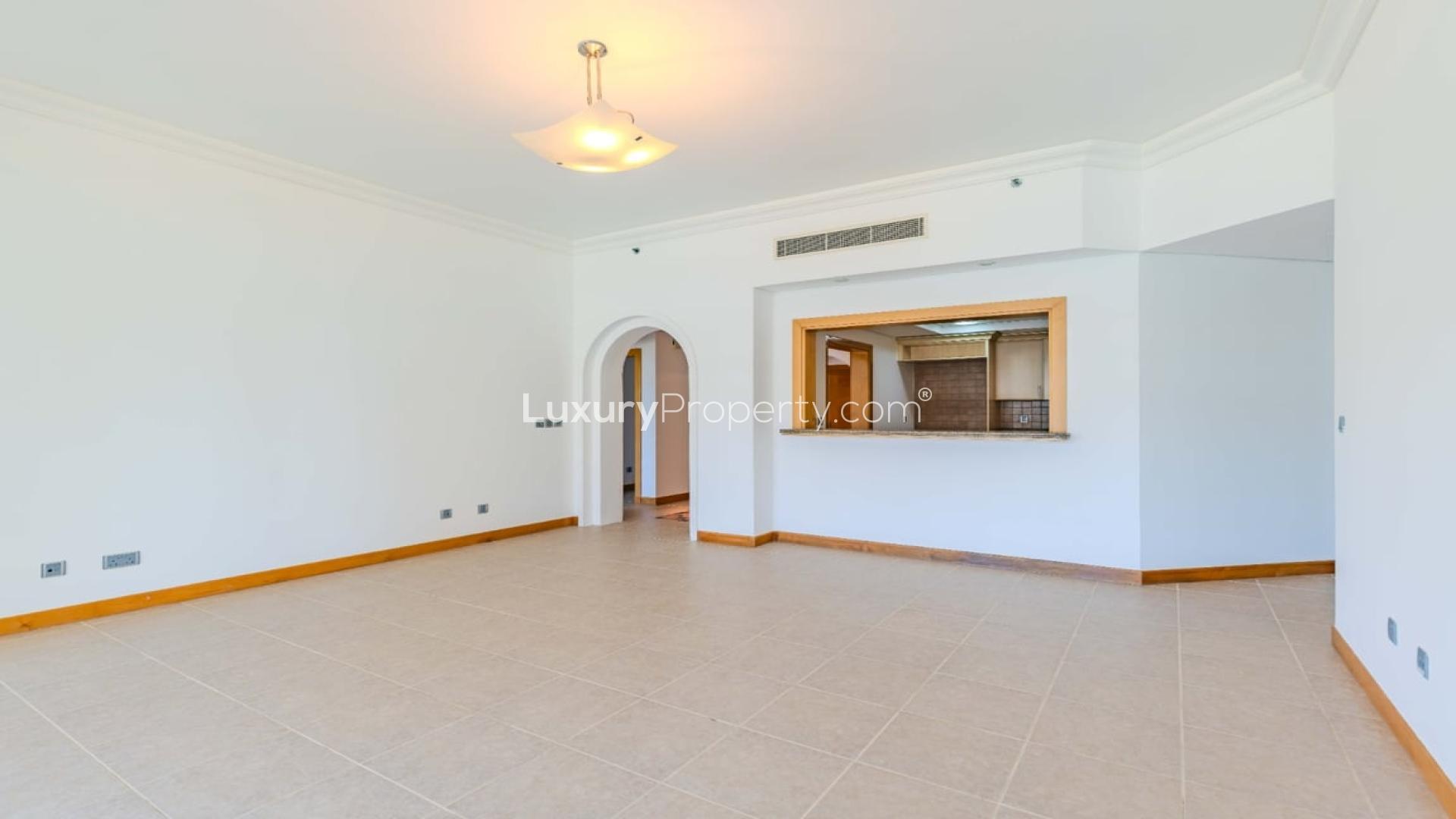 Empty living room in 2-bedroom apartment, Shoreline Apartments, Palm Jumeirah, with bright tiled floor