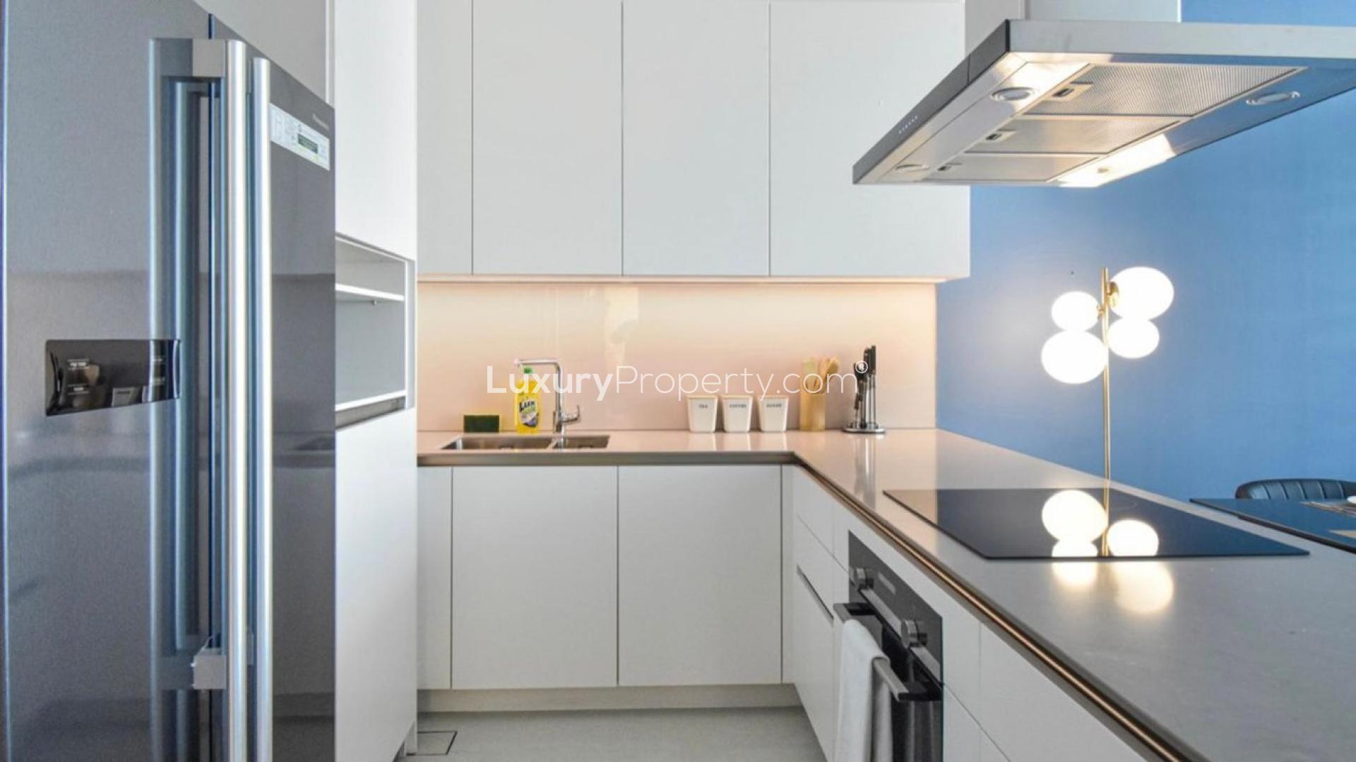 Furnished dining area in JBR apartment with modern decor and vibrant blue accent wall