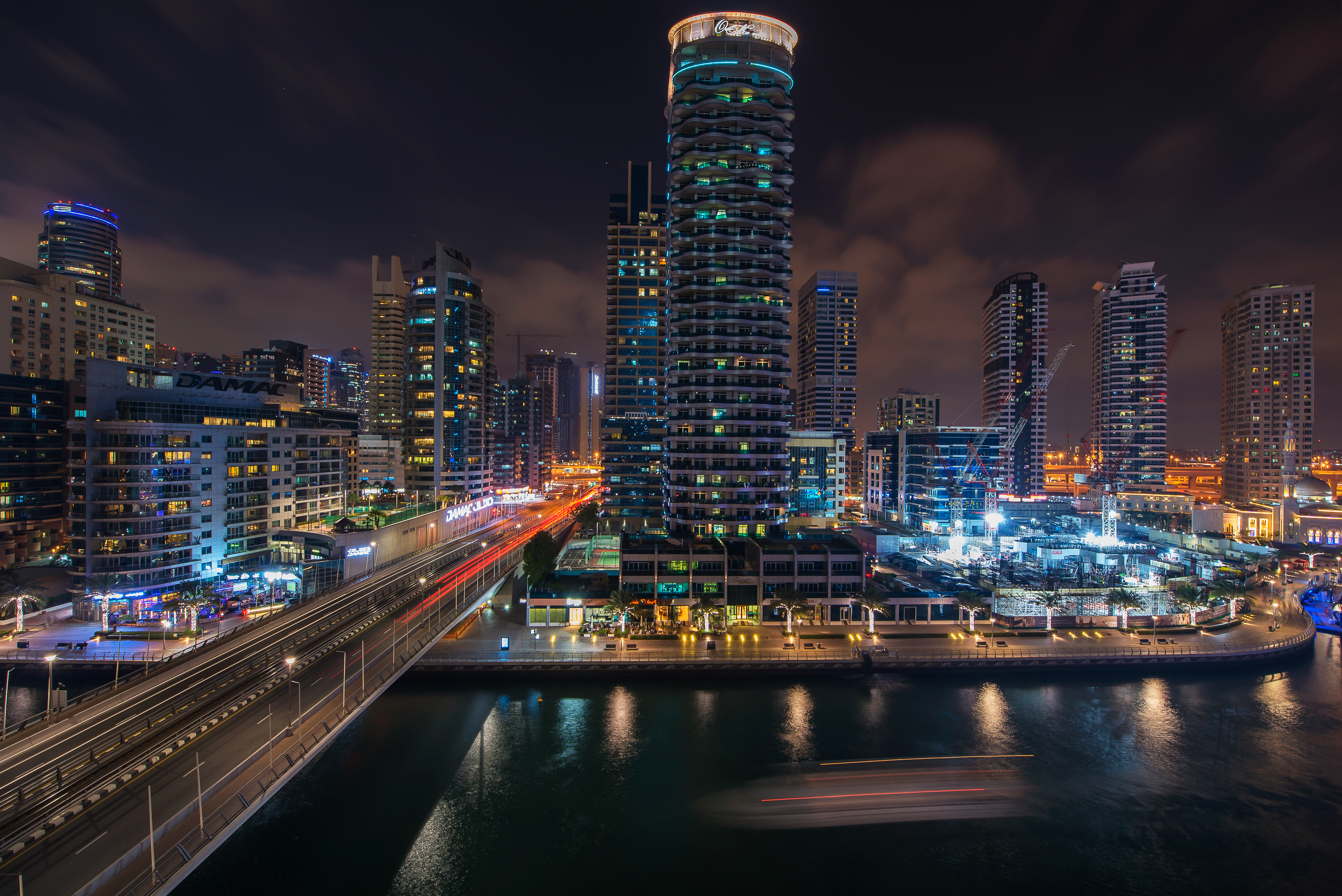 Night view of Downtown Dubai skyline near Burj Al Nujoom, vibrant city lights reflecting
