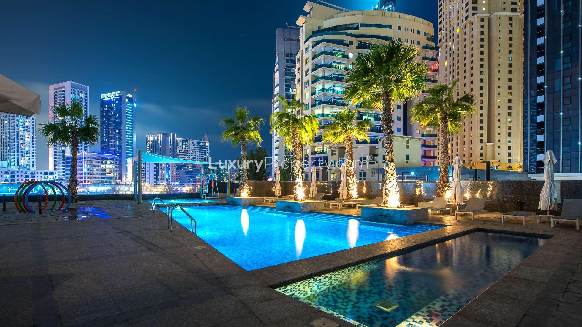 Stunning night view of Jumeirah Beach Residence waterfront with illuminated skyscrapers and marina