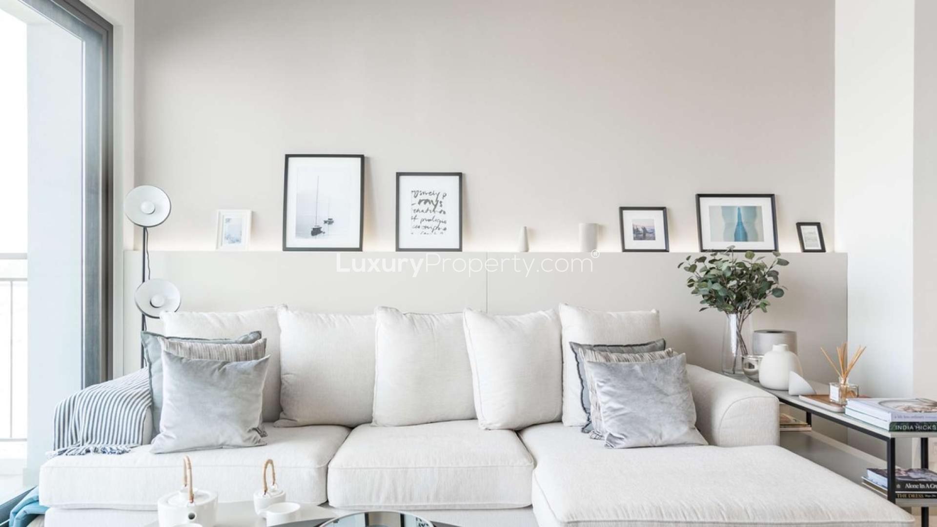 Majestic Emaar South apartment living room with cozy sofa and balcony view