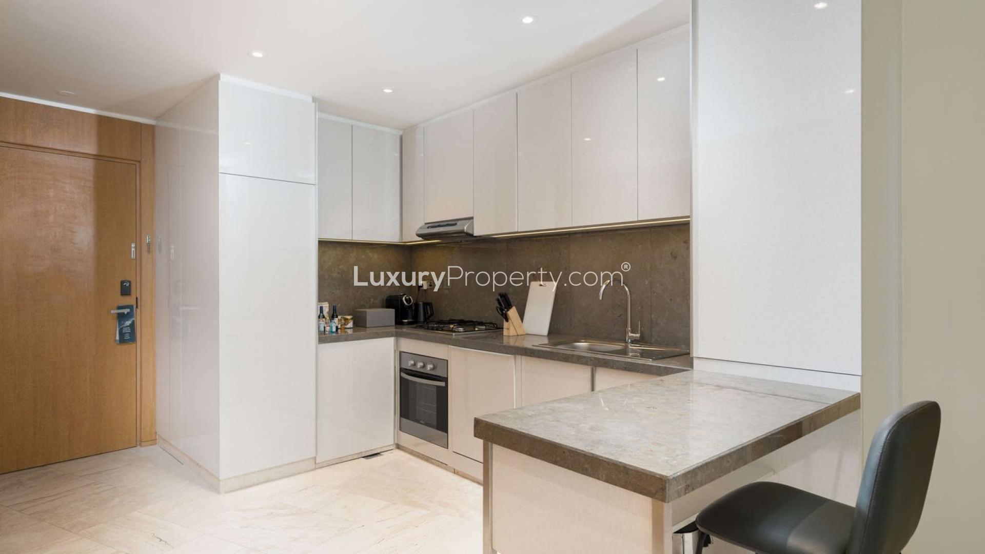 "Modern high-rise apartment building exterior at FIVE Jumeirah Village, stunning architecture and skyline views.","Modern kitchen in 2-bedroom Jumeirah Village Circle apartment with sleek cabinets and built-in appliances.",Modern living room in Jumeirah Village apartment with natural light and elegant decor