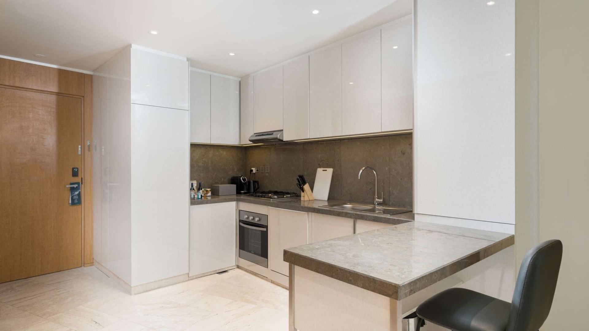 "Modern high-rise apartment building exterior at FIVE Jumeirah Village, stunning architecture and skyline views.","Modern kitchen in 2-bedroom Jumeirah Village Circle apartment with sleek cabinets and built-in appliances.",Modern living room in Jumeirah Village apartment with natural light and elegant decor