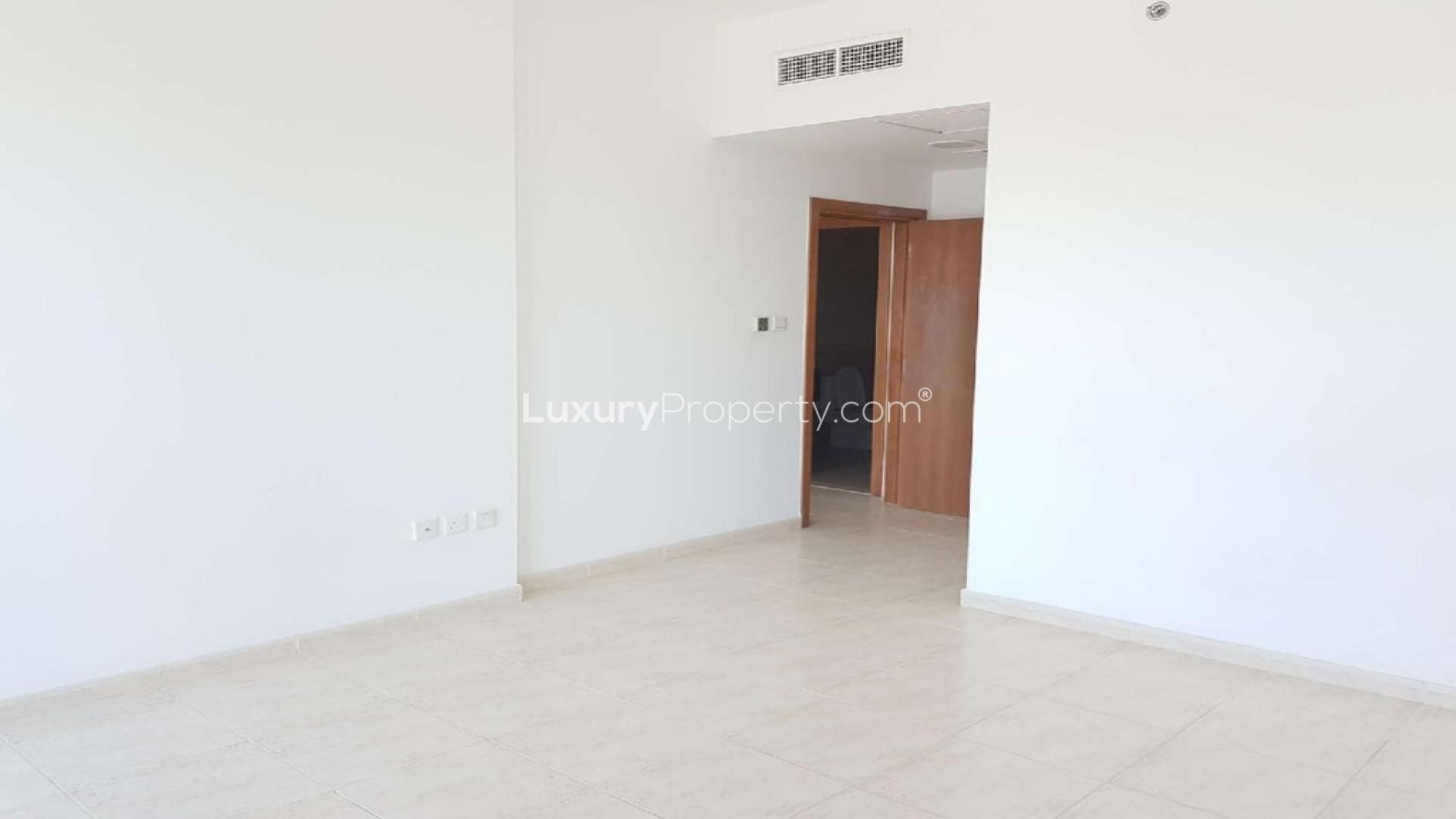 Bright living area with large windows in Skycourt Towers apartment, Dubailand for sale