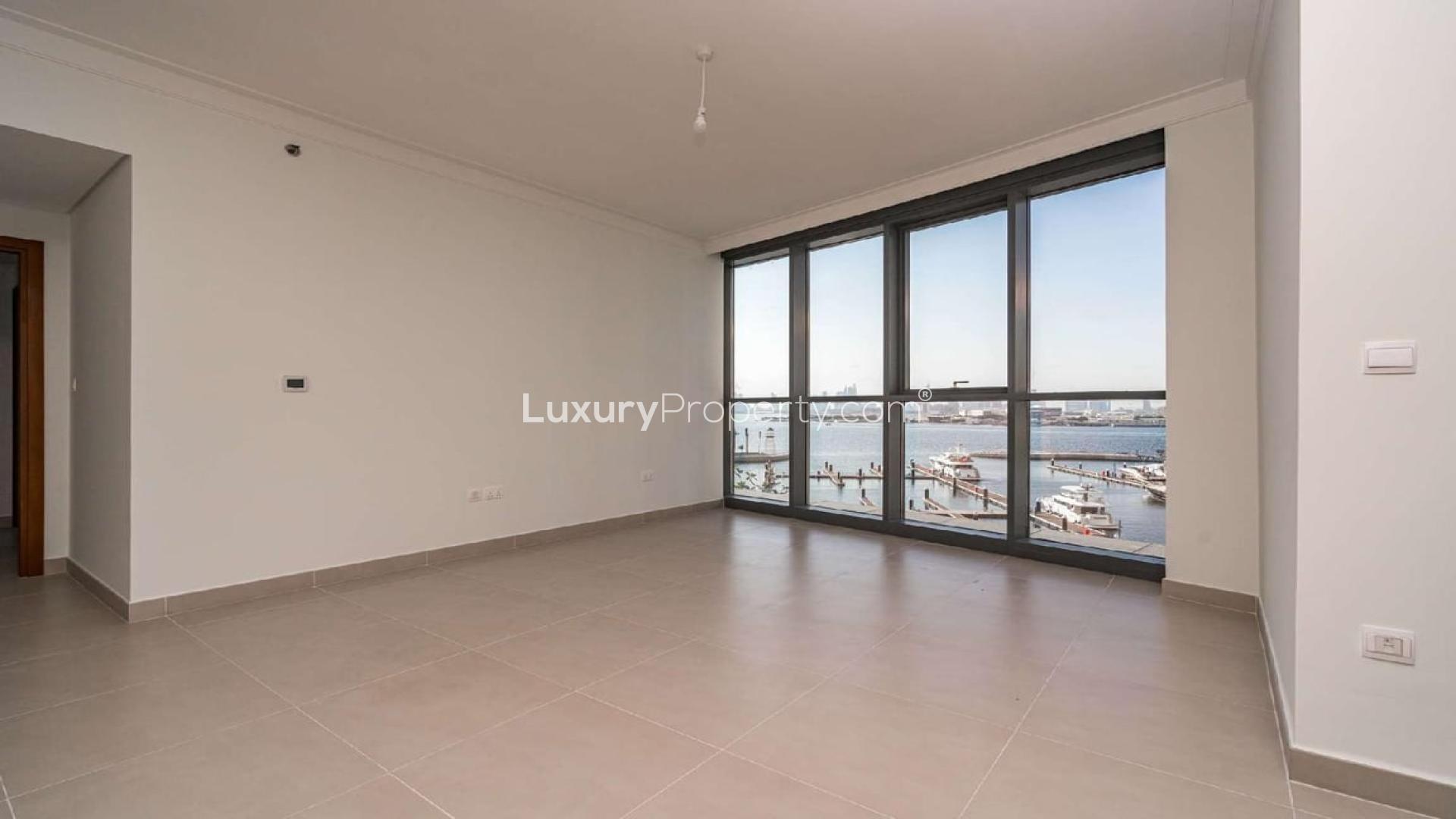 Empty living room with large windows offering waterfront views in Creek Harbour, Dubai apartment