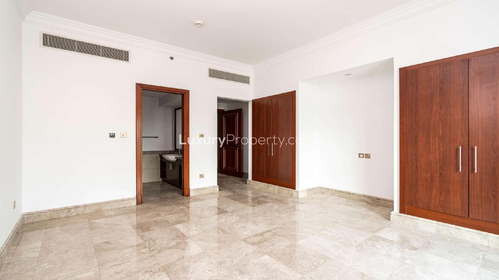 Modern kitchen in Palm Jumeirah apartment, featuring wooden cabinets and granite countertops