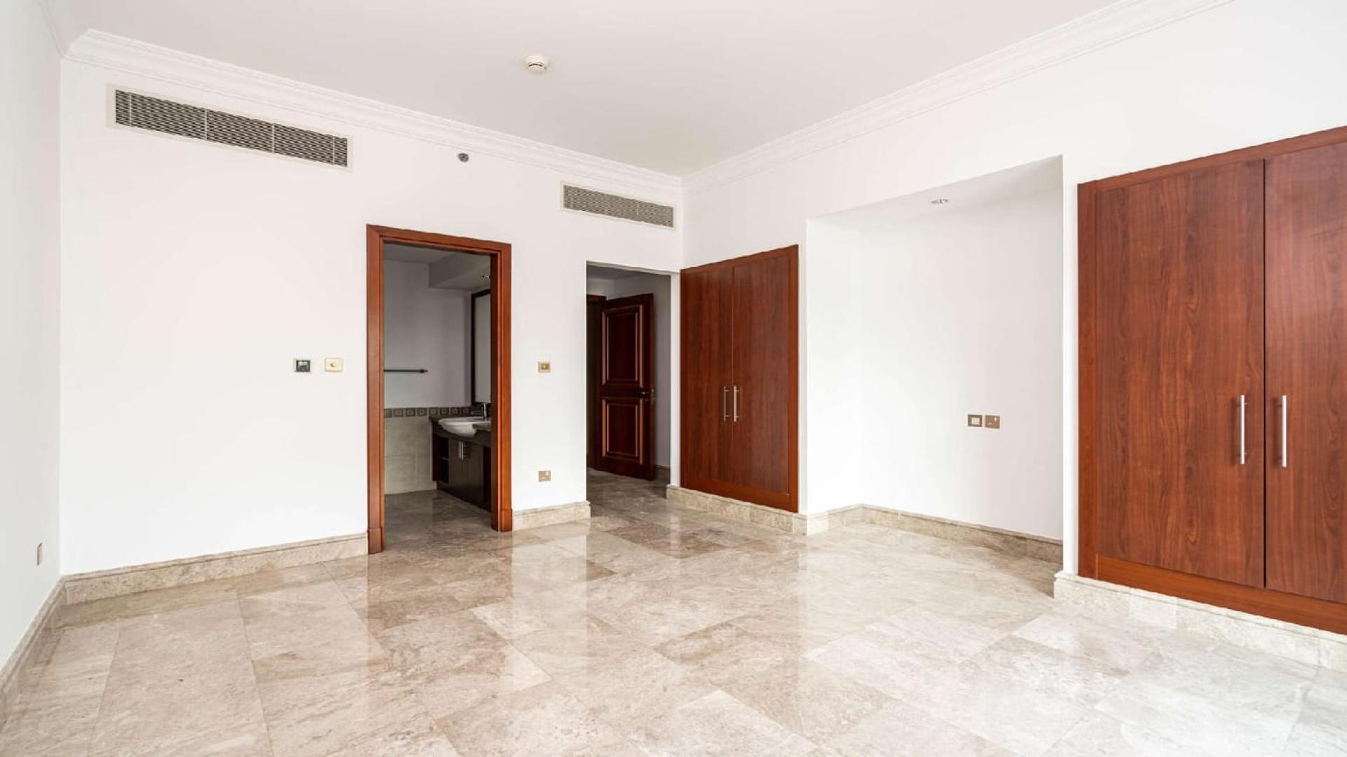 Modern kitchen in Palm Jumeirah apartment, featuring wooden cabinets and granite countertops