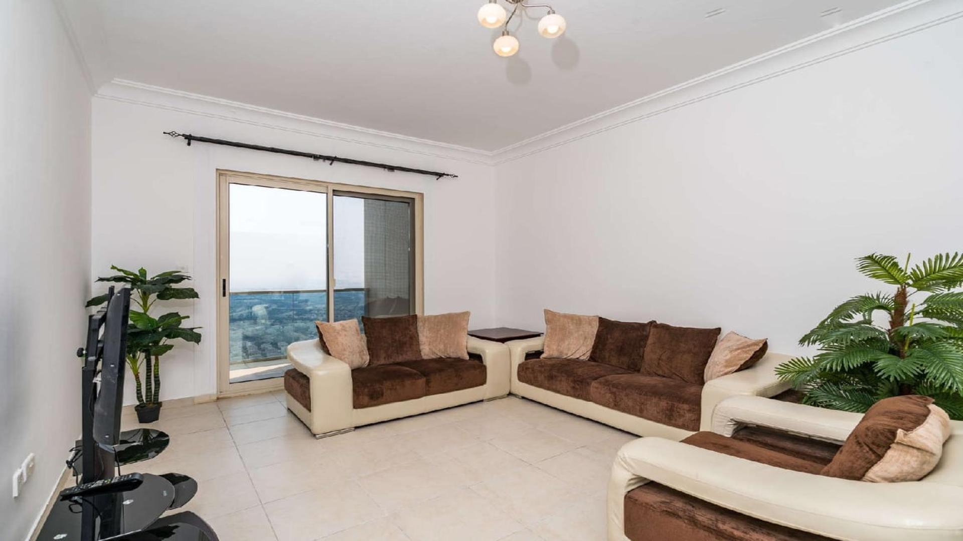 Spacious living room in JLT apartment with modern furniture and bright natural light