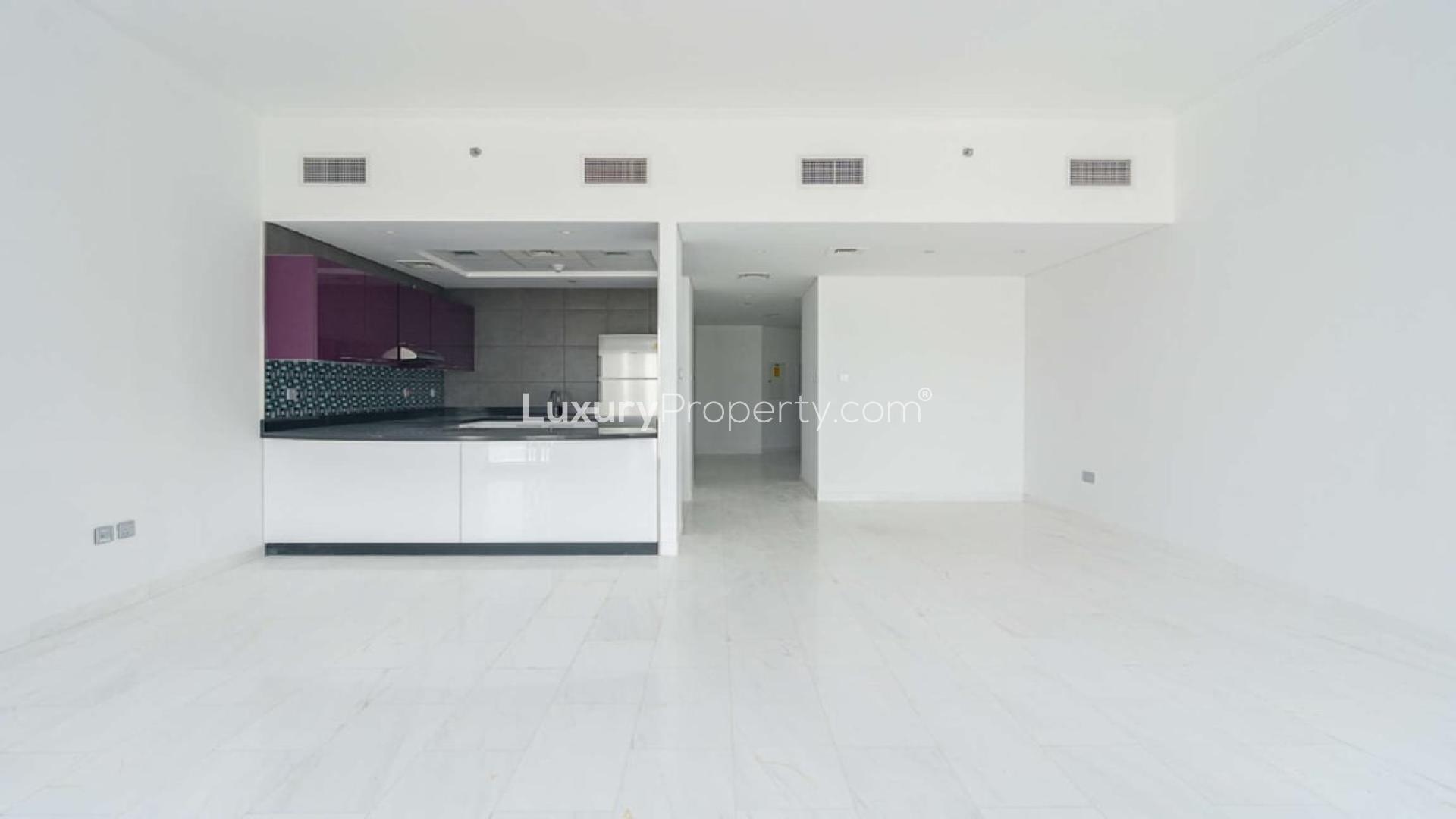 Modern kitchen in luxurious Dubai Marina studio apartment, featuring sleek purple cabinets and mosaic backsplash