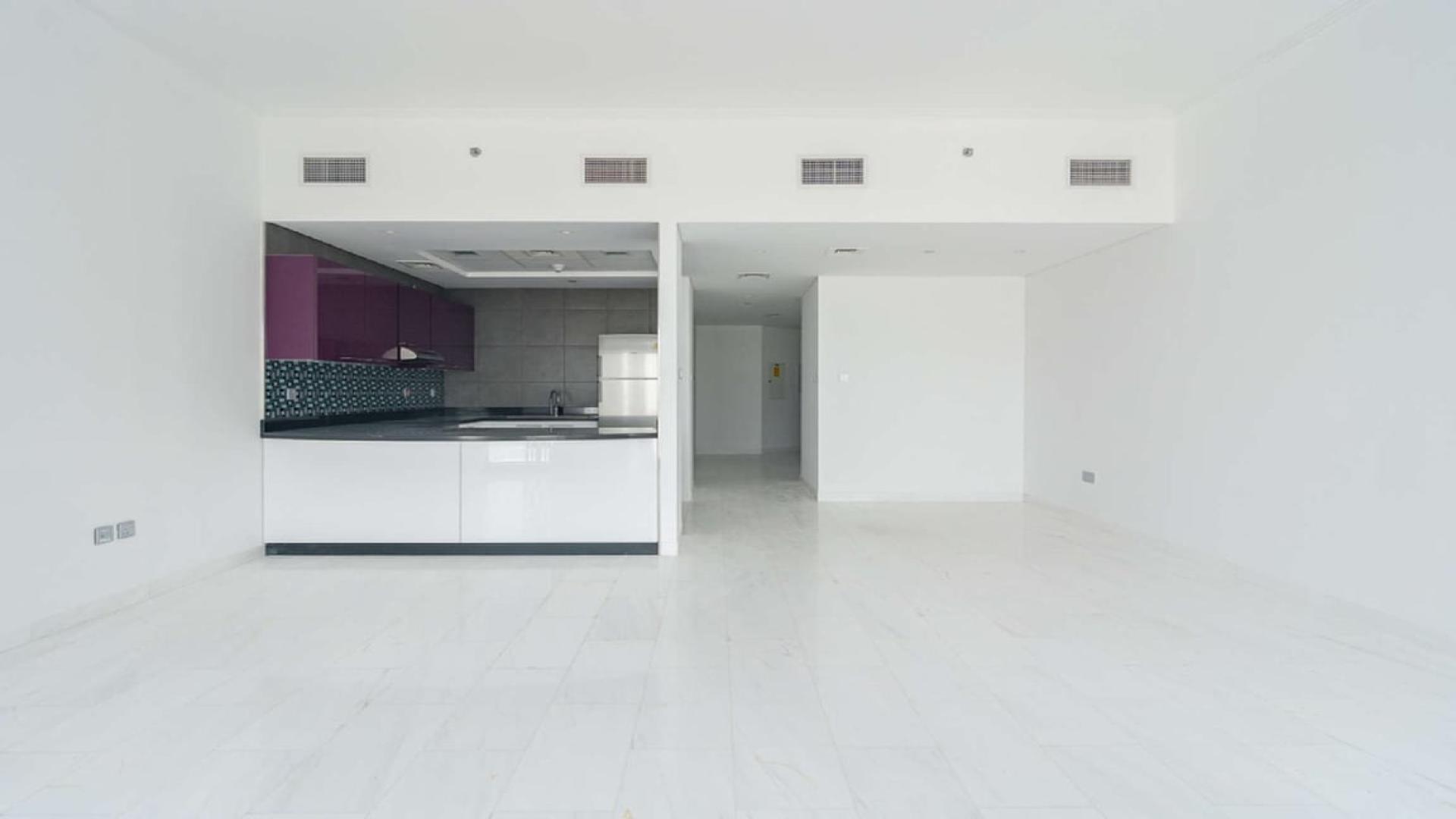 Modern kitchen in luxurious Dubai Marina studio apartment, featuring sleek purple cabinets and mosaic backsplash