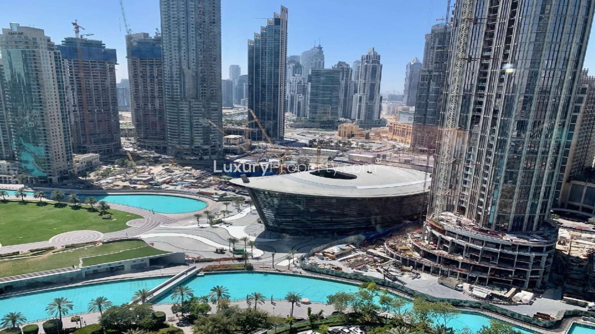 Alt text: "View of Dubai Fountain and skyscrapers from furnished apartment in Downtown Dubai, Burj Khalifa Area.",Furnished apartment view of Dubai Fountain, Downtown Dubai, Burj Khalifa Area, for sale