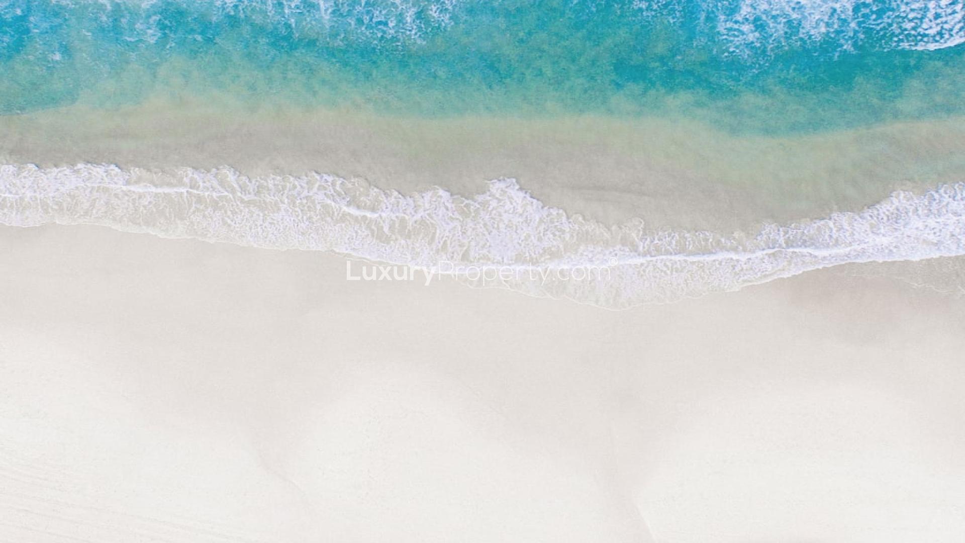 Aerial view of pristine beach and turquoise waves at Emaar Beachfront, Dubai Harbour apartment