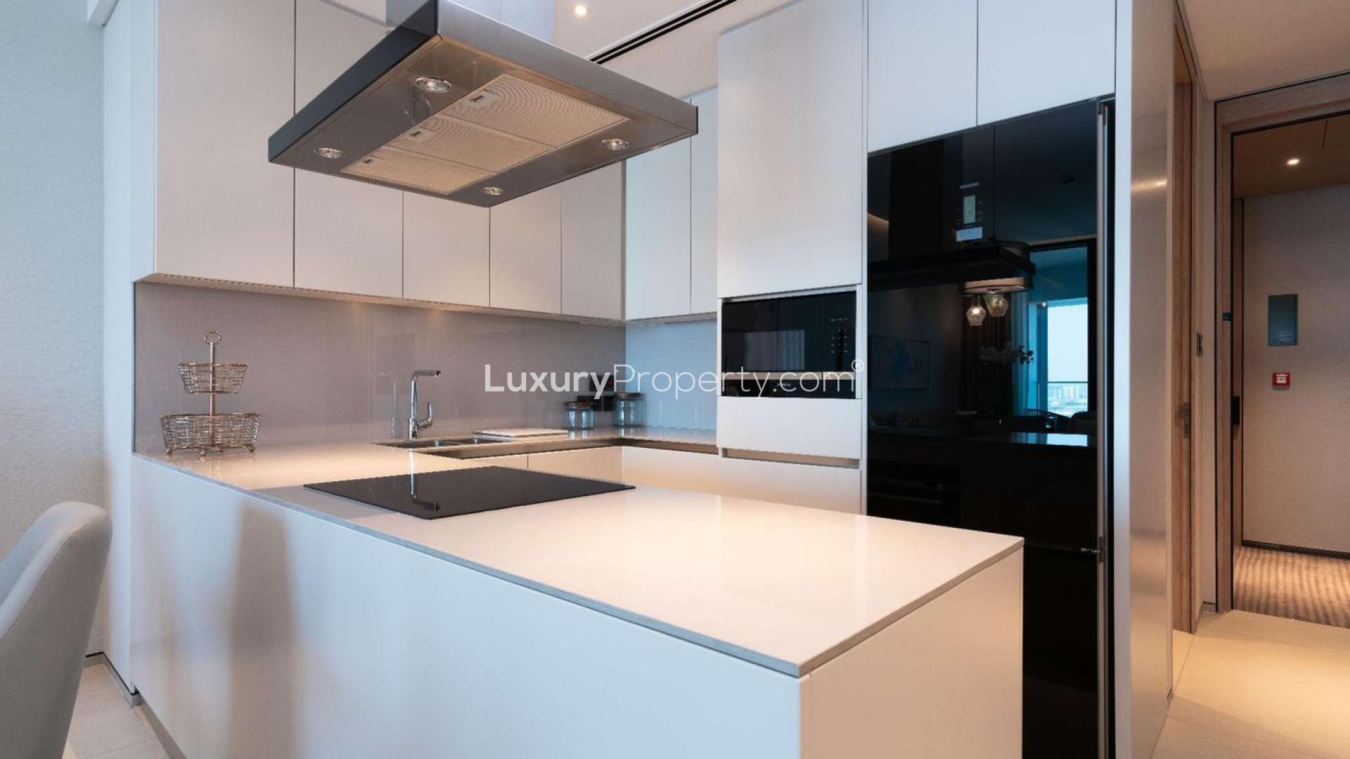 "High-floor serviced apartment bedroom with marina view, Jumeirah Beach Residence, for sale.",Modern kitchen in serviced holiday flat, high floor, Marina view, Jumeirah Beach Residence apartment