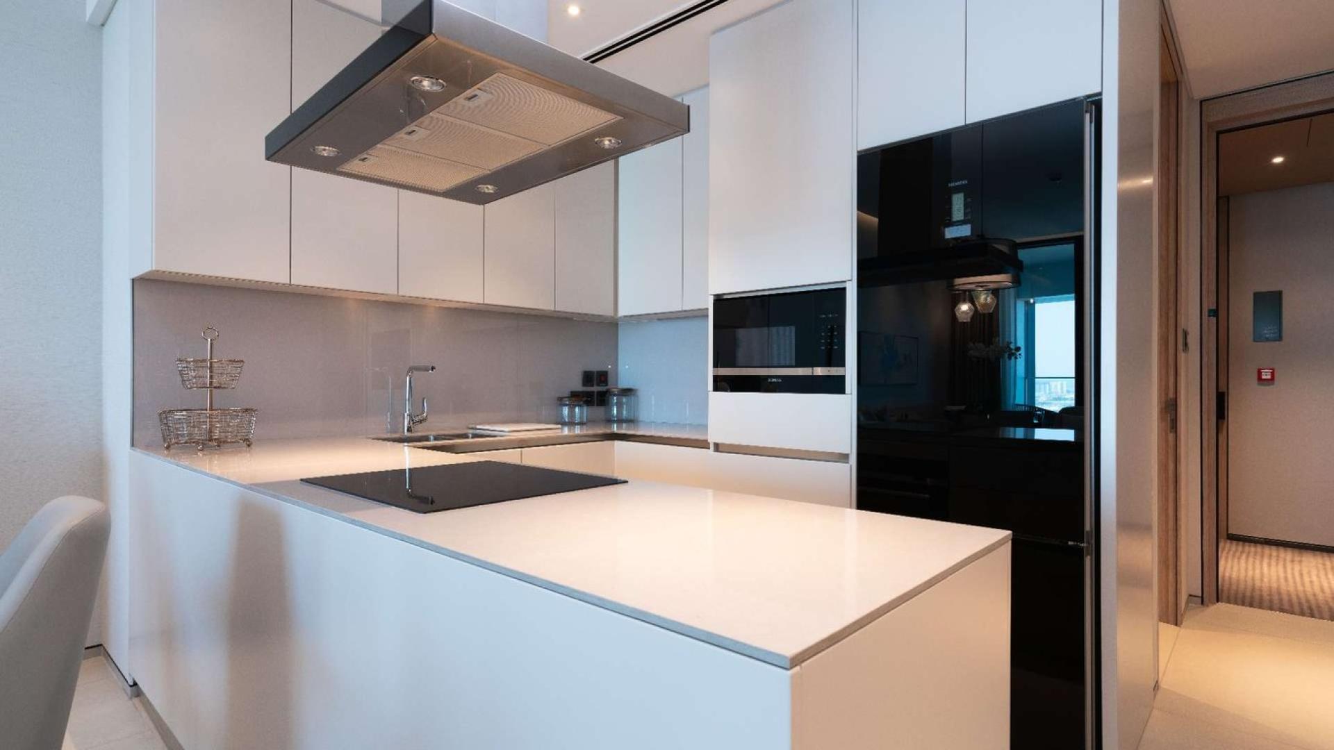 "High-floor serviced apartment bedroom with marina view, Jumeirah Beach Residence, for sale.",Modern kitchen in serviced holiday flat, high floor, Marina view, Jumeirah Beach Residence apartment