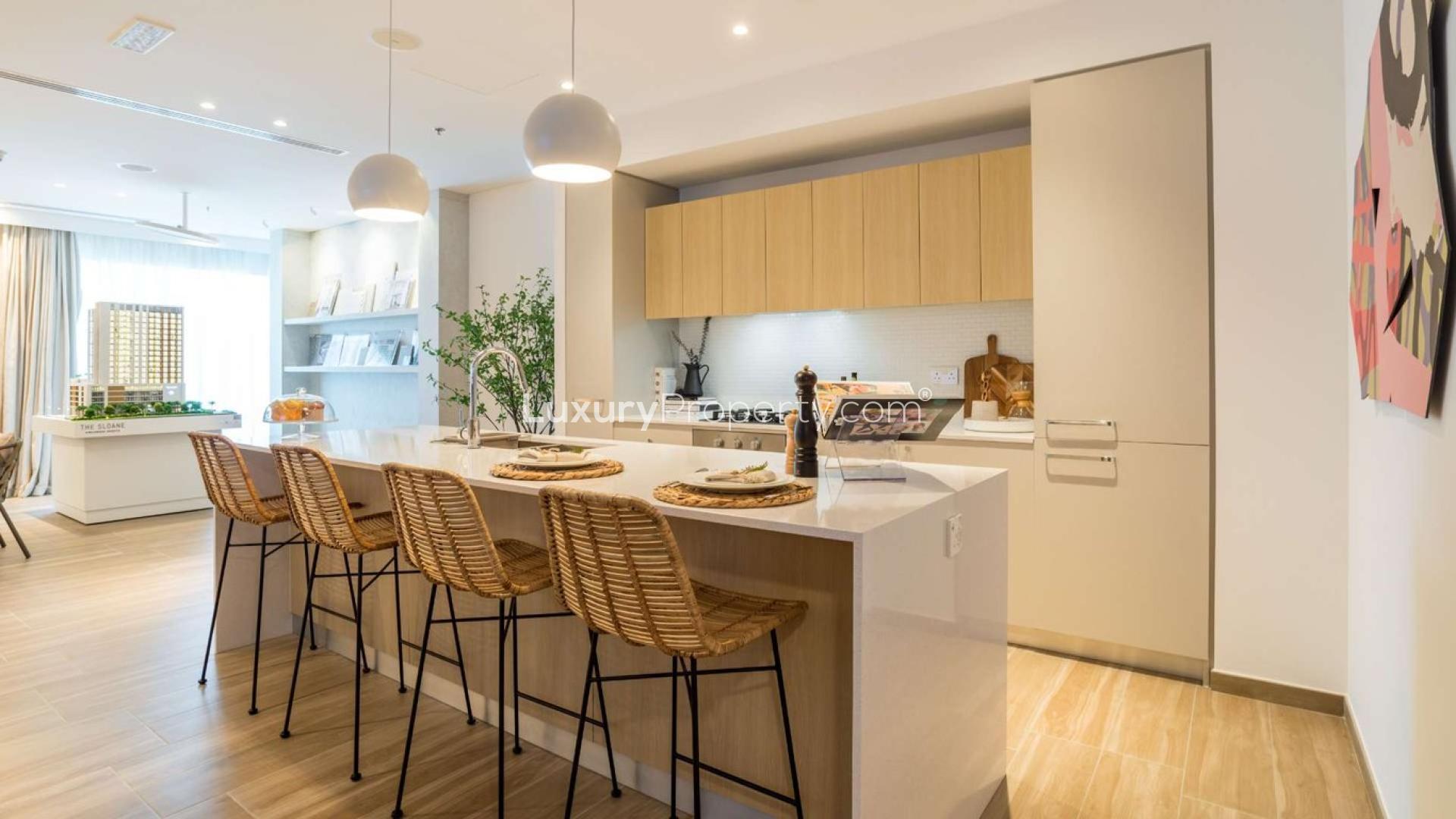 "Stylish dining area in 2-bedroom apartment, The Sloane, Jumeirah Village Circle, for sale.",Modern kitchen with island seating in JVC apartment for sale, The Sloane community