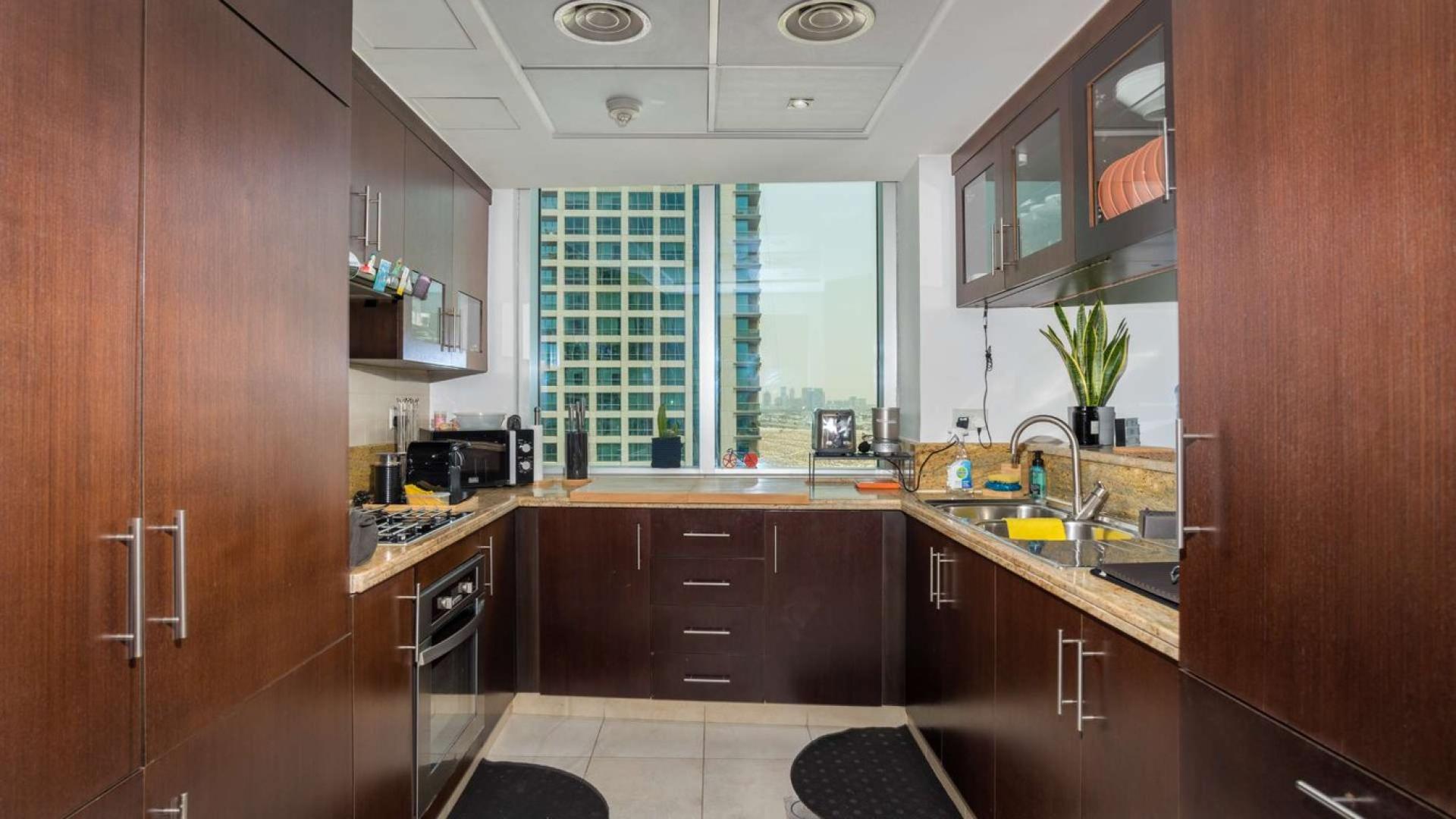 Bright living room in The Fairways apartment with panoramic city views, The Views community