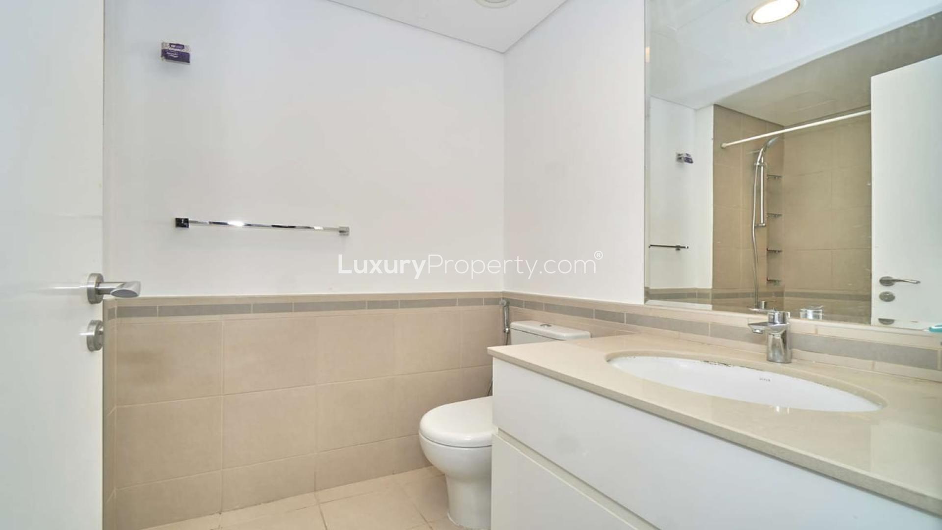 Modern kitchen in 2-bedroom Zahra apartment, Town Square, featuring sleek cabinetry and dining area