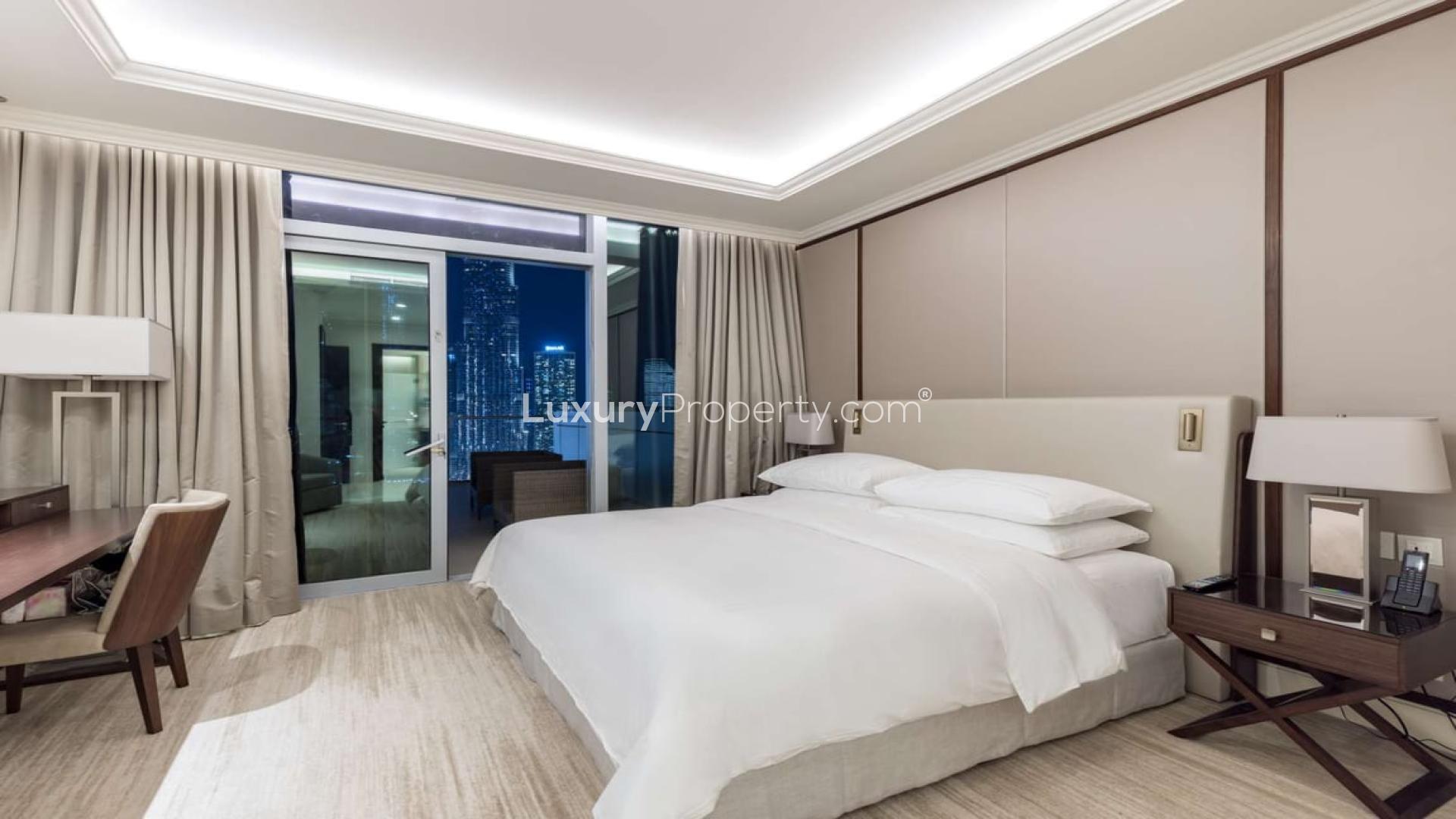 Night view of Downtown Dubai skyline and fountains from apartment in The Address Residence