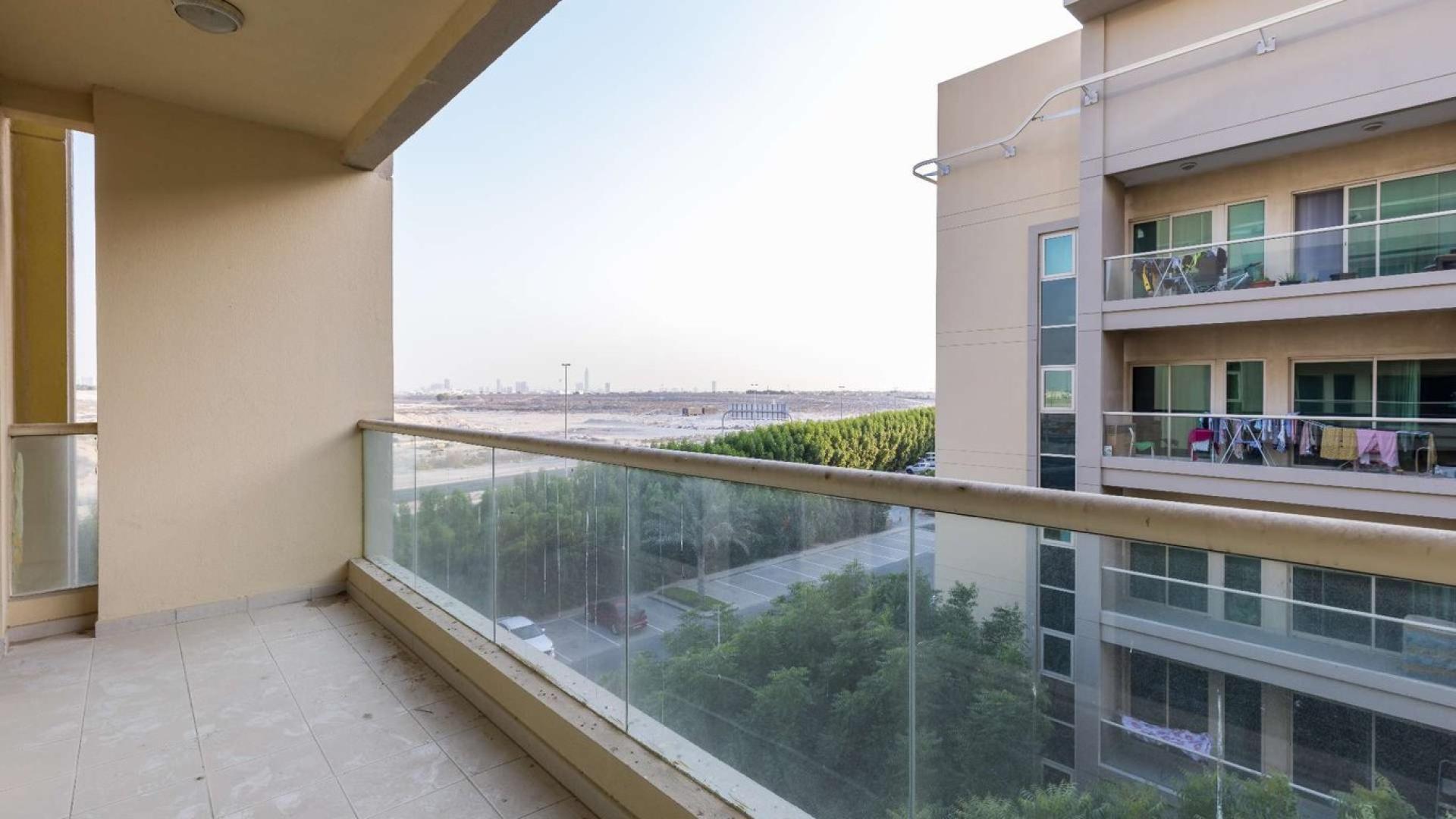 Spacious living room in 2-bedroom Al Alka apartment with large windows, tiled floor