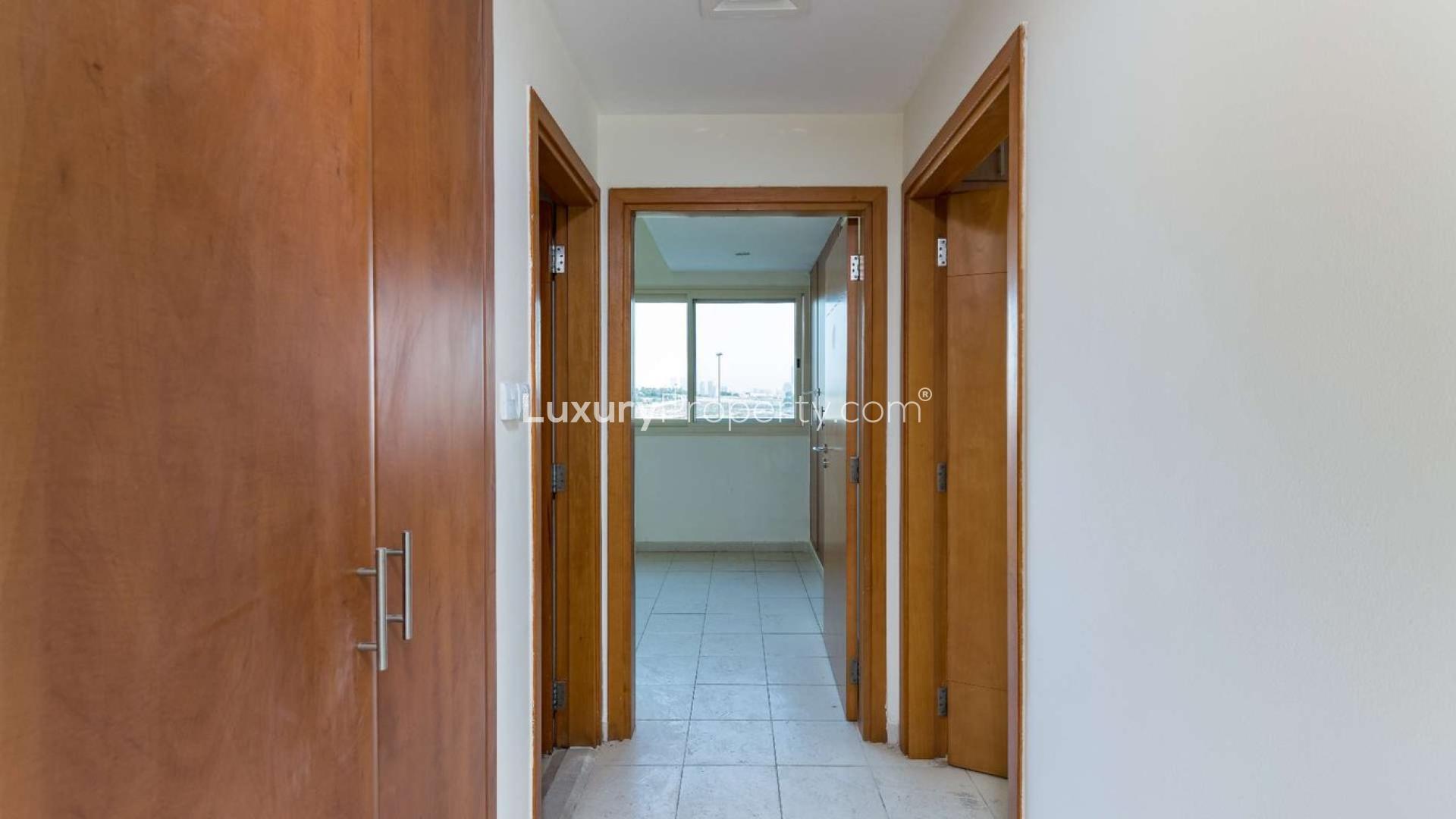 Empty living space in Al Alka apartment with tiled floor and open kitchen area