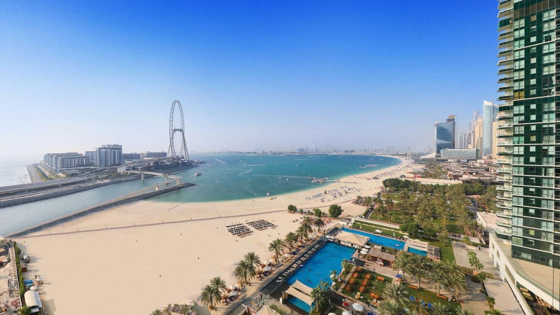 "Beachfront apartment interior with ocean view, Jumeirah Beach Residence, for sale.",Empty room with large windows showcasing beach and ocean view at Jumeirah Beach Residence