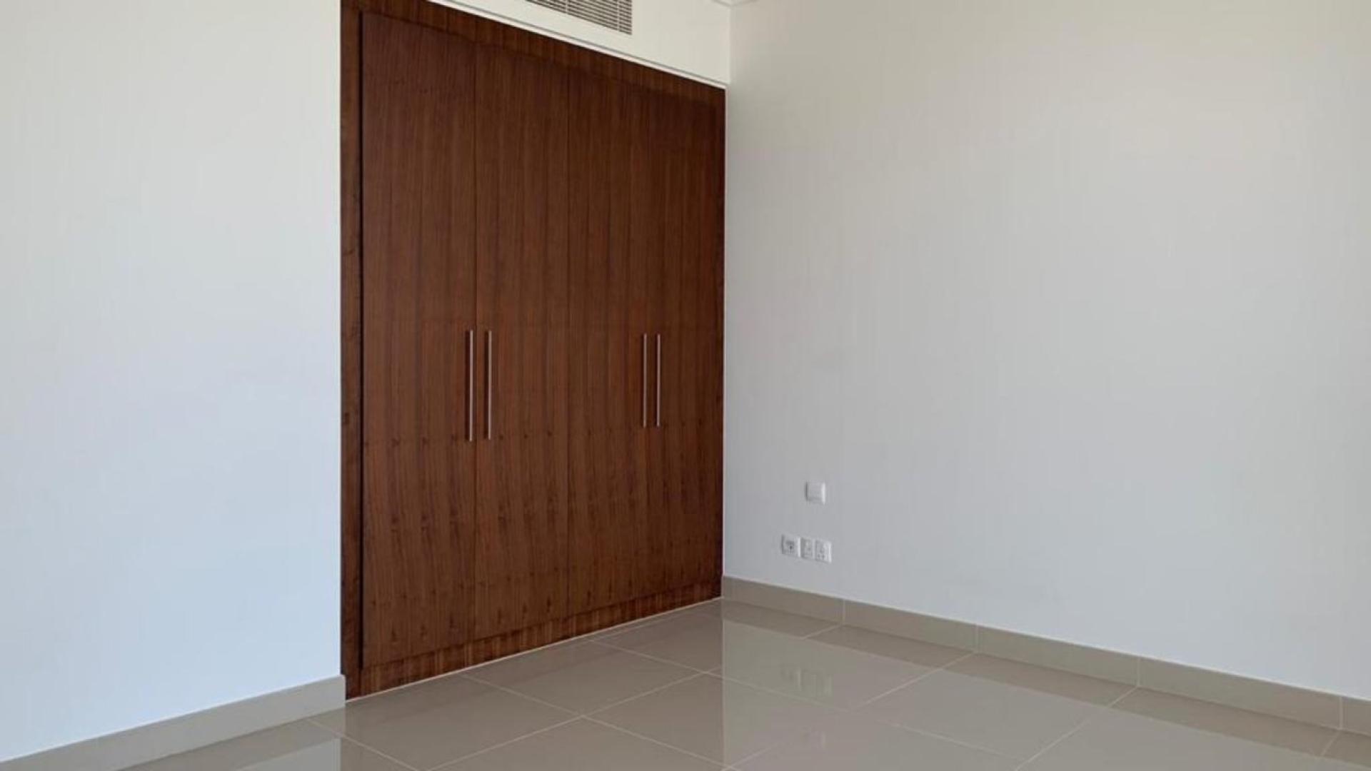 "Spacious apartment with stunning canal and city view in Boulevard Point, Downtown Dubai.",Empty bedroom with built-in wooden wardrobe in Boulevard Point apartment, Downtown Dubai
