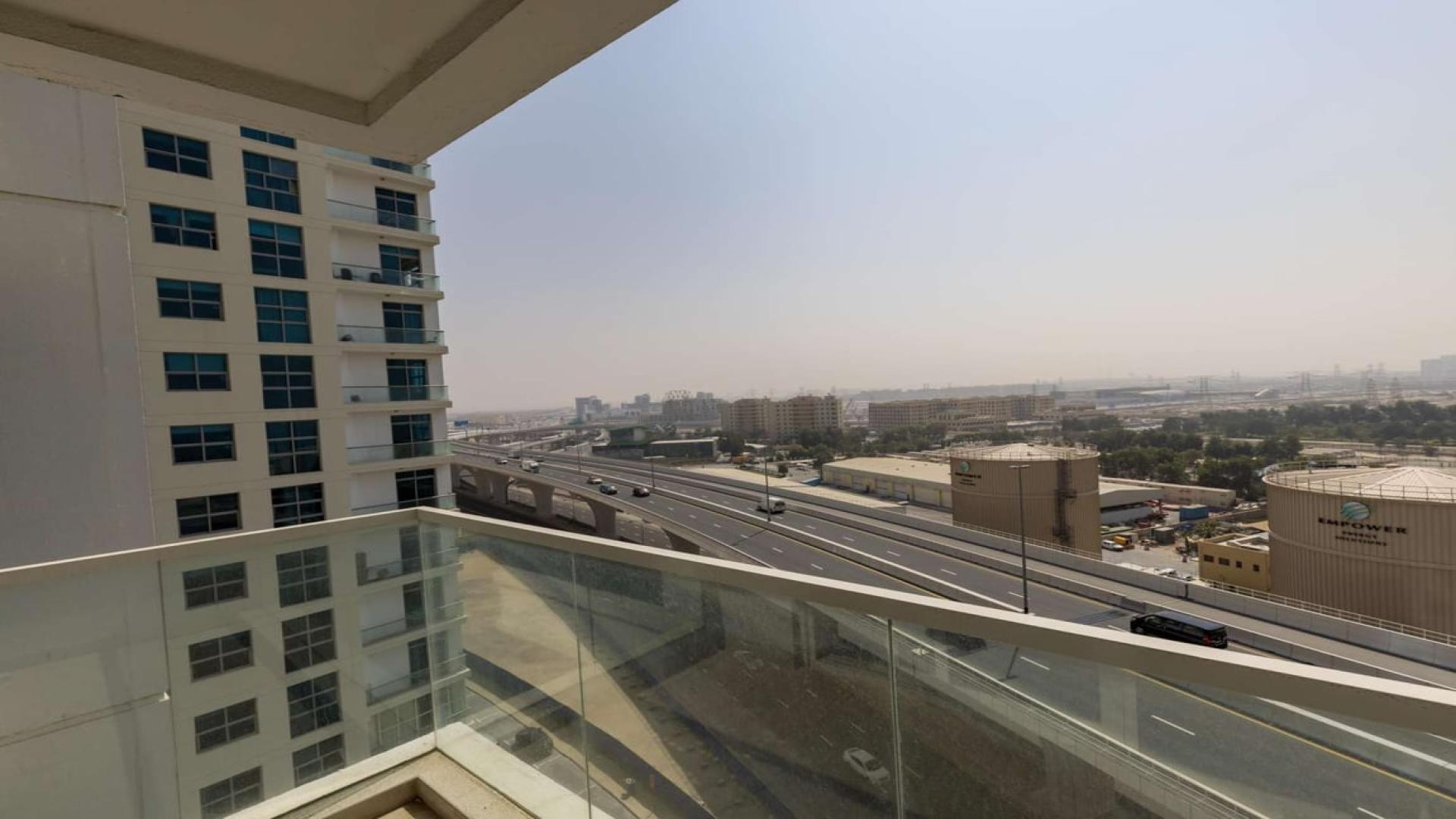 Balcony view from modern apartment in Studio One, Dubai Marina overlooking highway and buildings