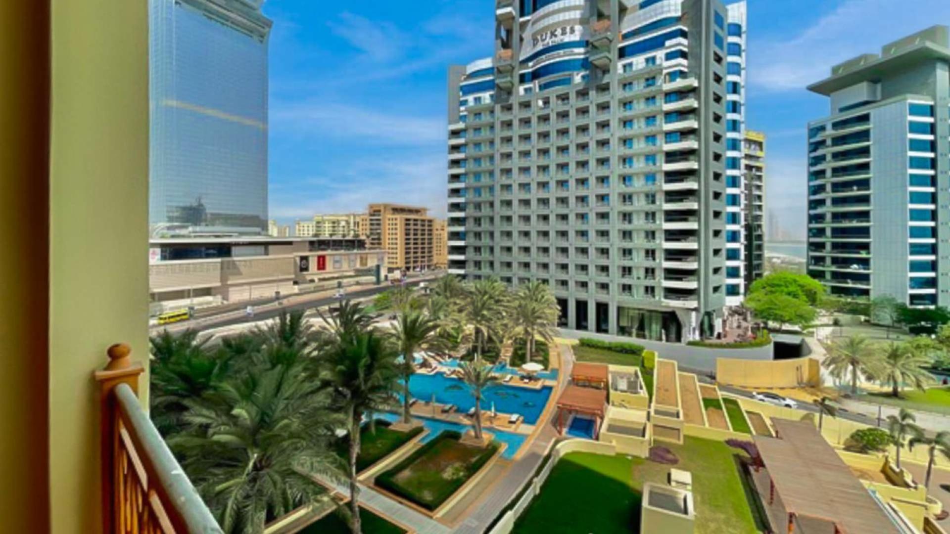 "Spacious living area in 2-bedroom Palm Jumeirah villa with marina views for sale.","Palm Jumeirah apartment balcony view of Marina Residences and pool area, Dubai.",Modern kitchen in spacious 2-bedroom villa, Palm Jumeirah Marina Residences, for sale