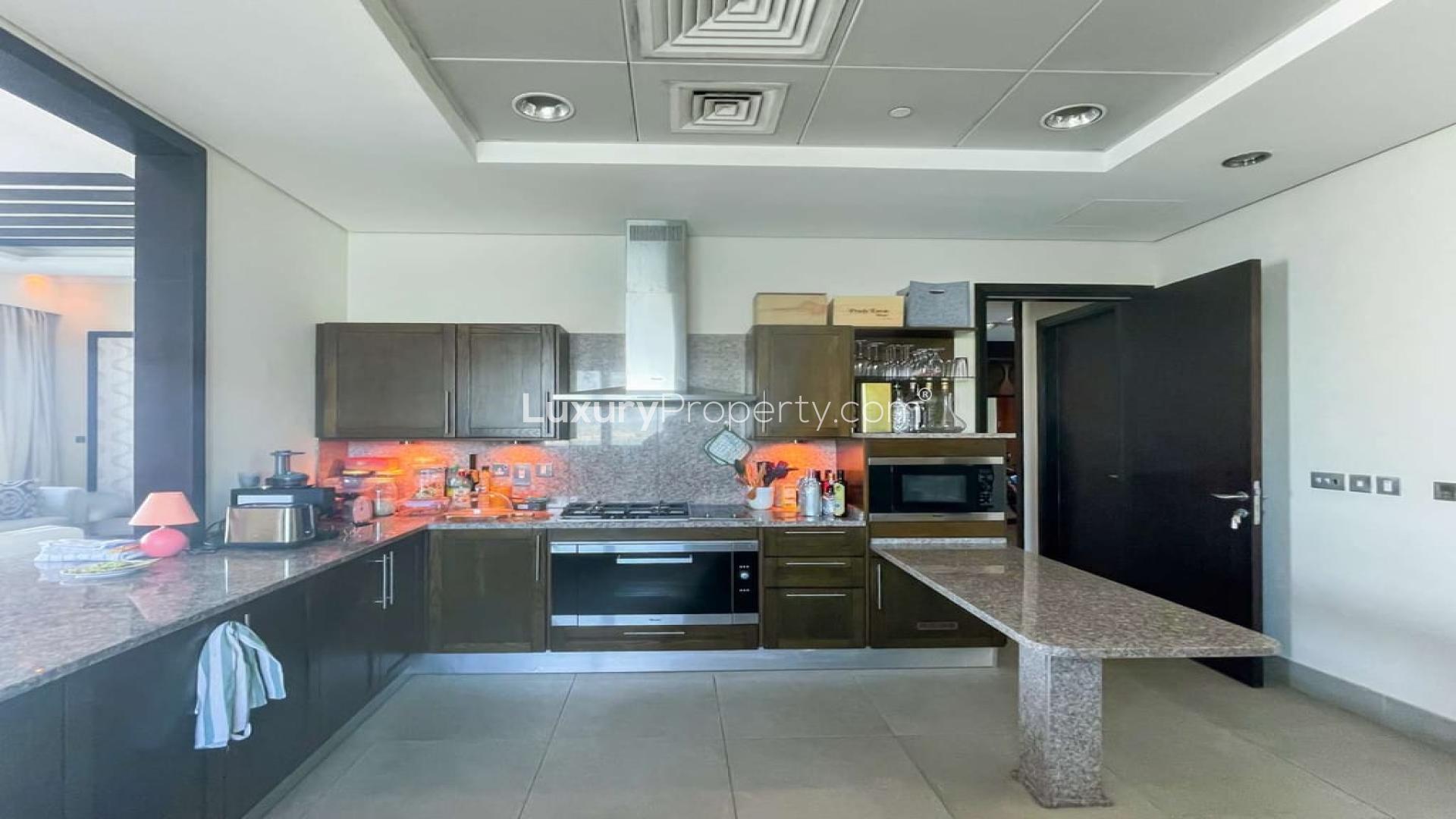 Modern kitchen in Palm Jumeirah apartment, featuring sleek countertops and built-in appliances