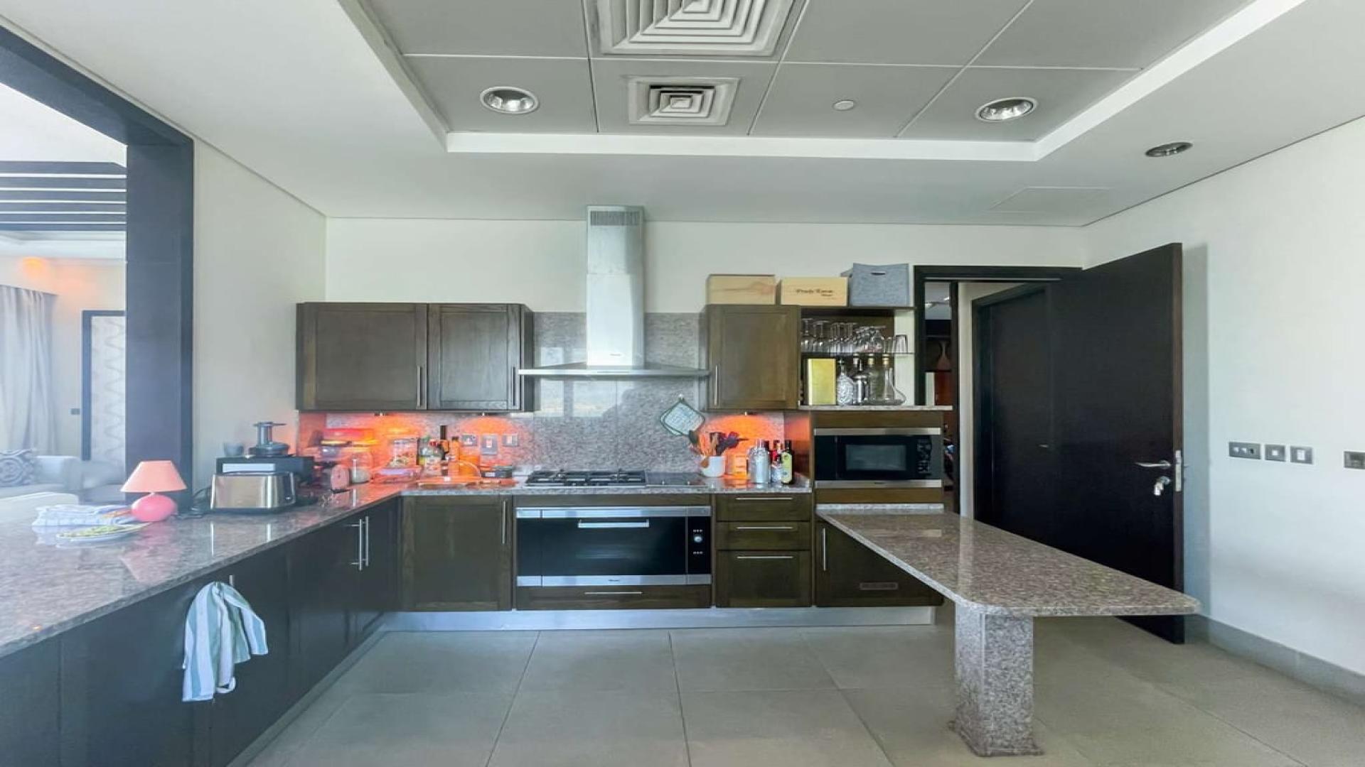 Modern kitchen in Palm Jumeirah apartment, featuring sleek countertops and built-in appliances