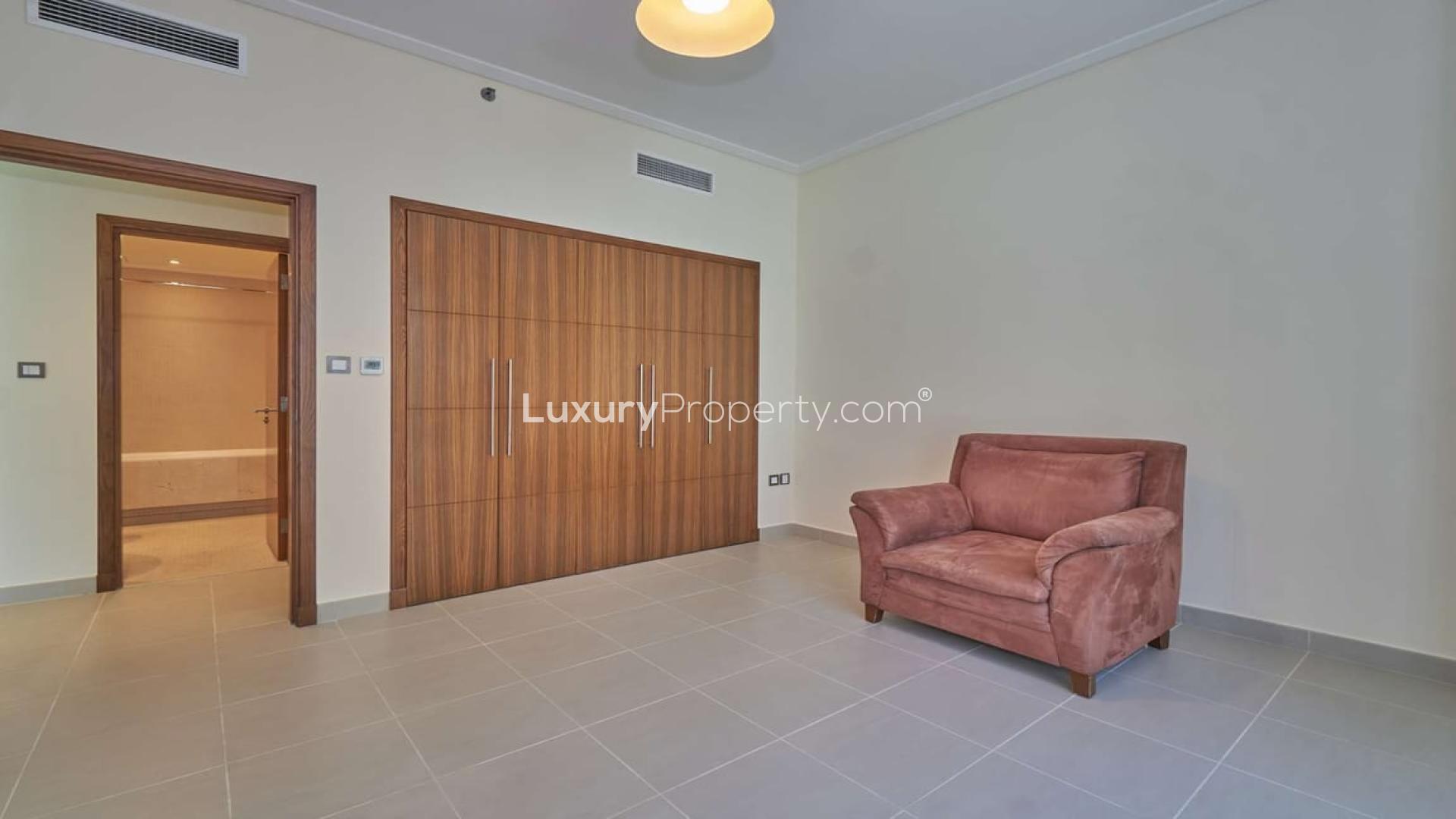 Empty room with built-in wardrobe and pink armchair in Dubai Marina apartment for sale