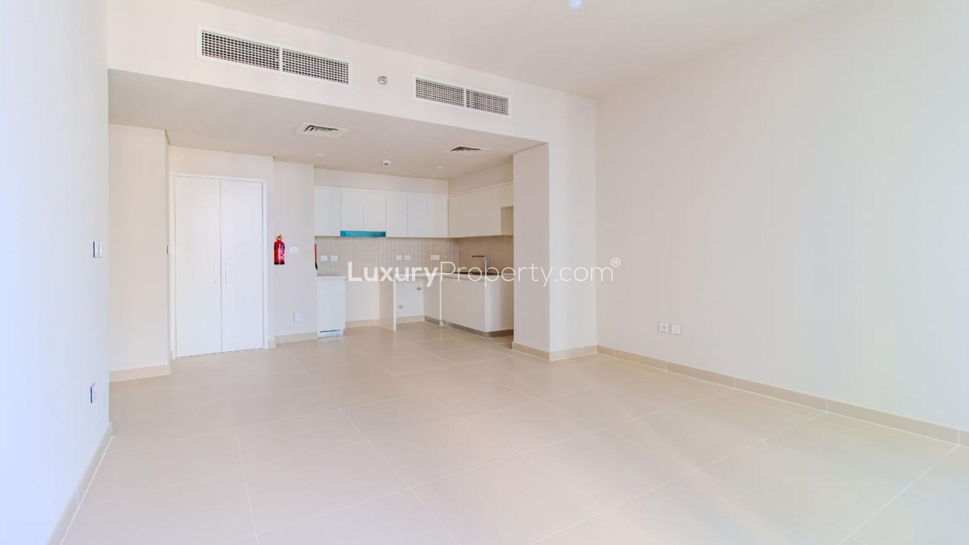 Empty apartment room with floor-to-ceiling windows and balcony view in Dubai Creek Harbour