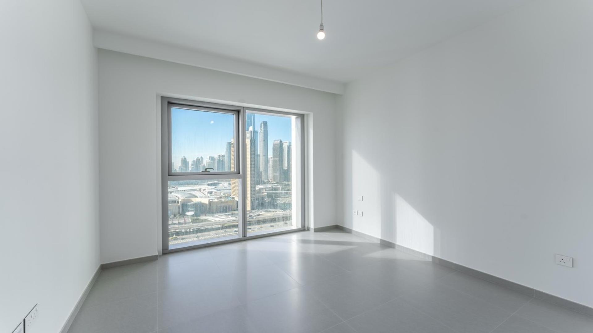 Modern kitchen in Downtown Dubai apartment, featuring sleek white cabinets and built-in appliances