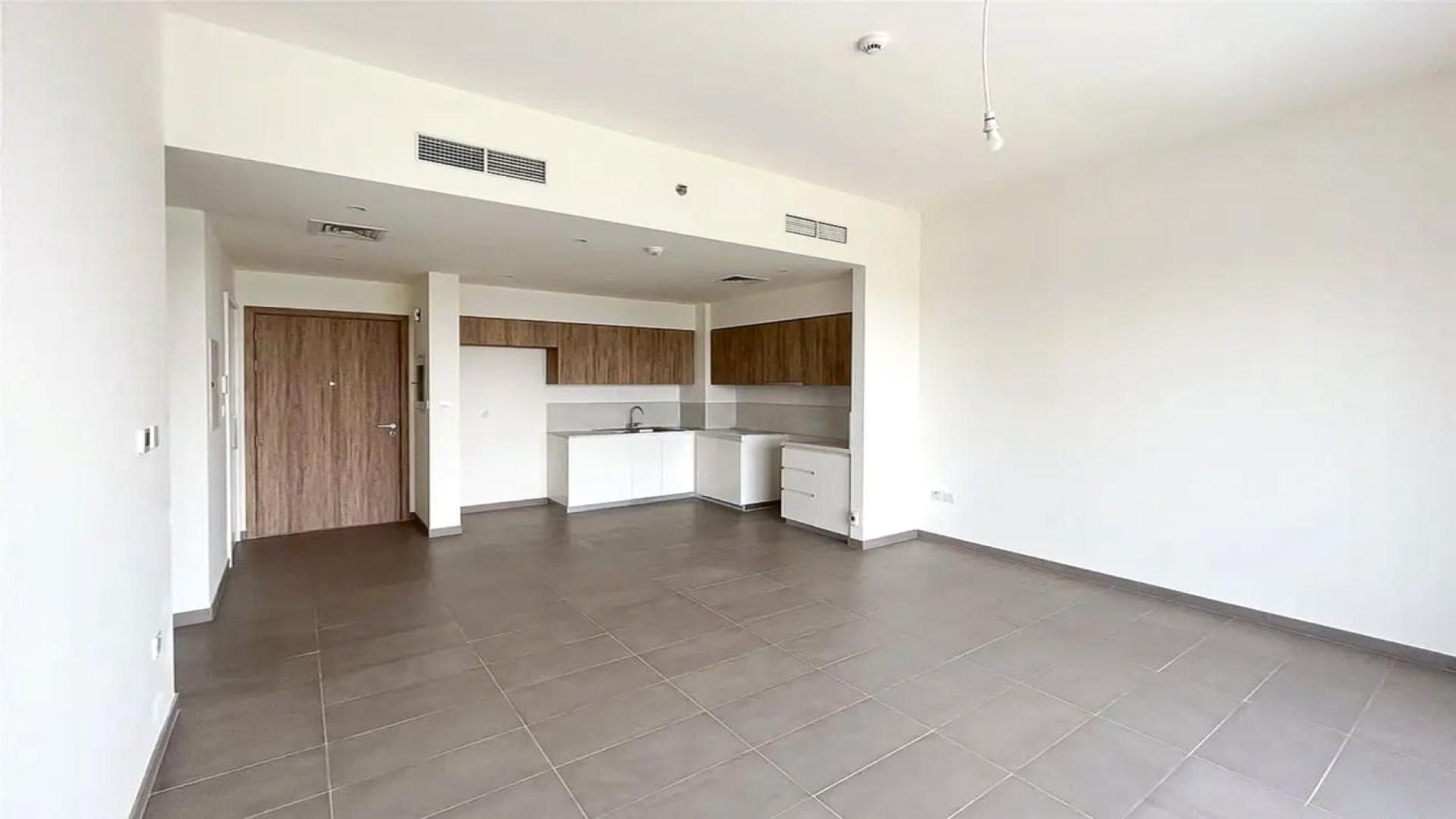 "Luxury apartment with pool and park view in Dubai Hills Estate, Executive Residences.",Modern kitchen and living area in Dubai Hills Estate apartment, Executive Residences