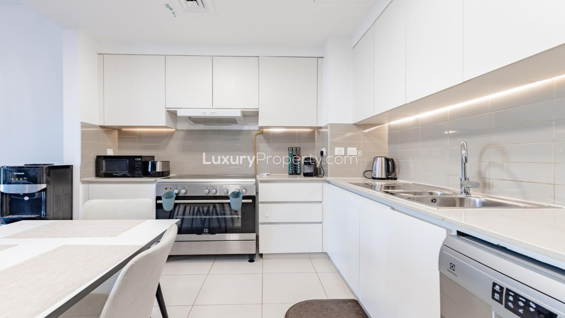 Modern kitchen and dining area in 2-bedroom Zahra Breeze apartment, Town Square, for sale