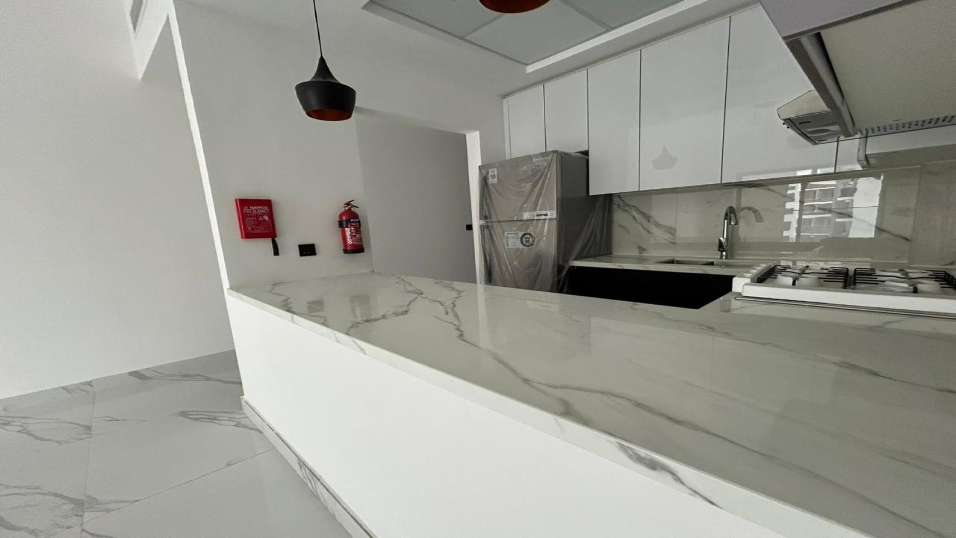 "Modern kitchen with marble countertops in 2-bedroom apartment for sale, Gardenia Livings, Arjan.","Modern kitchen with marble countertops in Arjan apartment, Gardenia Livings, for sale.",Brand new apartment kitchen in Gardenia Livings, Arjan with modern design and marble flooring