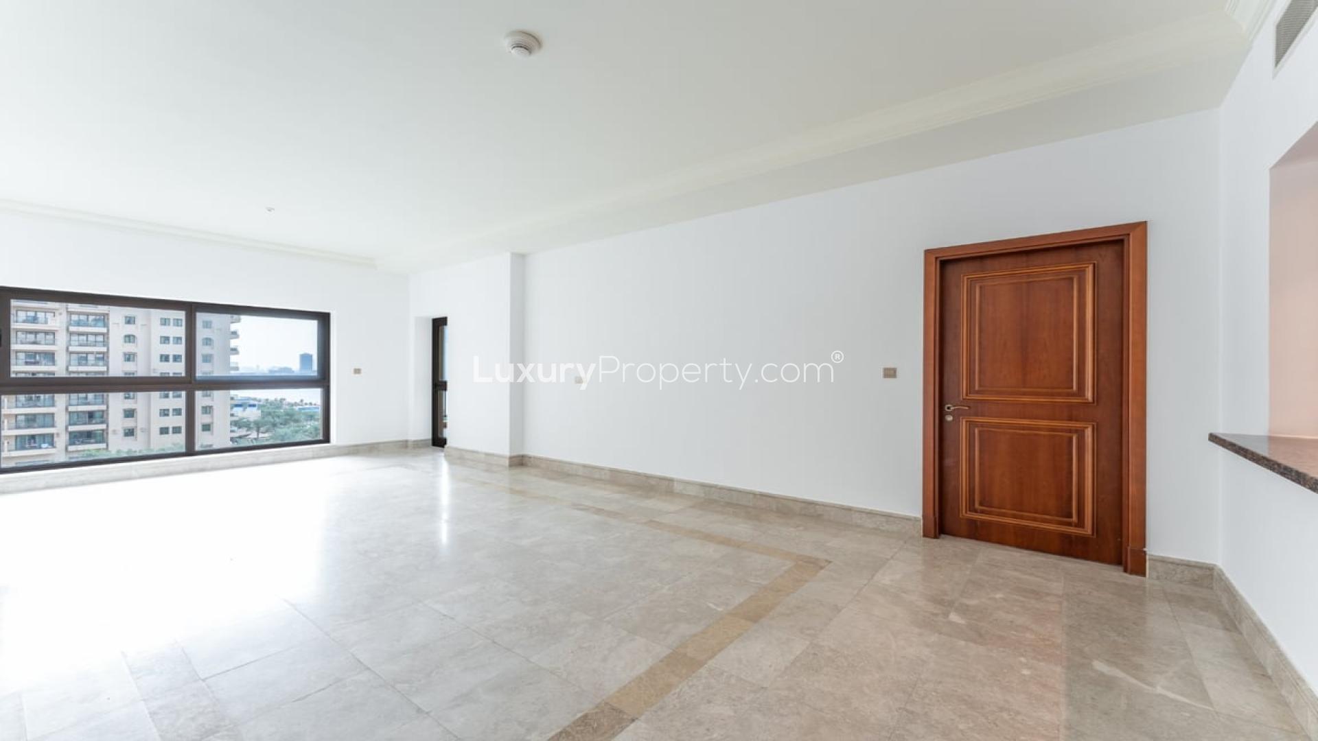 "Spacious living area in 2-bedroom apartment at The Fairmont Palm Residences, Palm Jumeirah.",Empty spacious living room in The Fairmont Palm Residences apartment, marble flooring, large window
