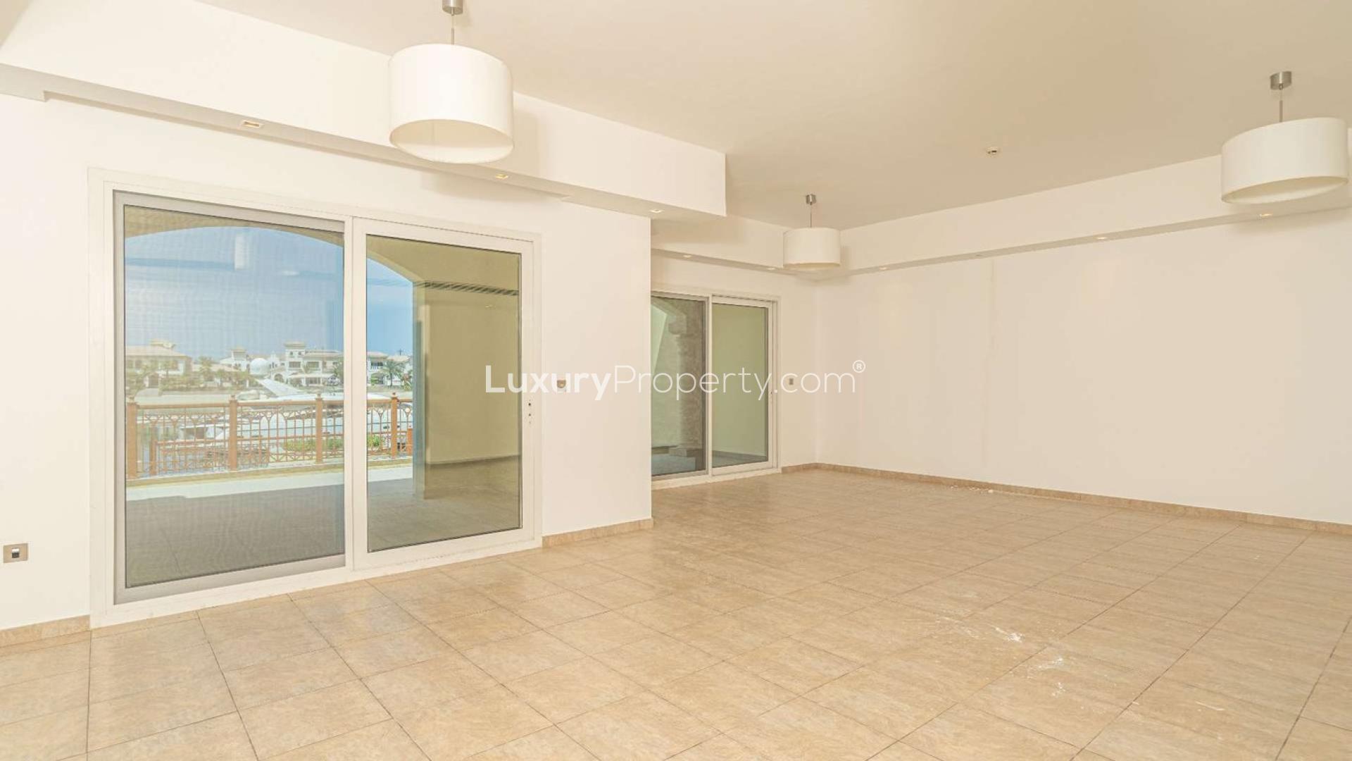 "Elegant townhouse in Marina Residences, Palm Jumeirah, with stunning architecture and lush greenery.",Spacious living room with marina view in Palm Jumeirah townhouse for sale