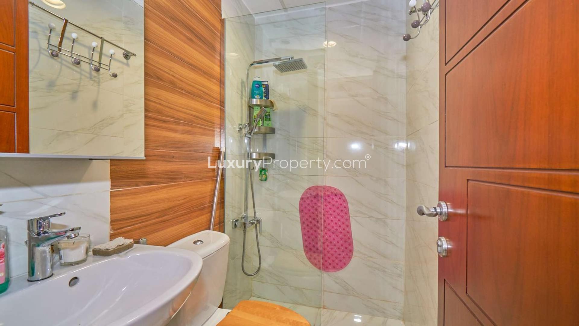 "Charming backyard of fully upgraded Springs villa with lush garden and patio furniture.",Modern bathroom in fully upgraded Springs Villa with marble tiles and glass shower enclosure