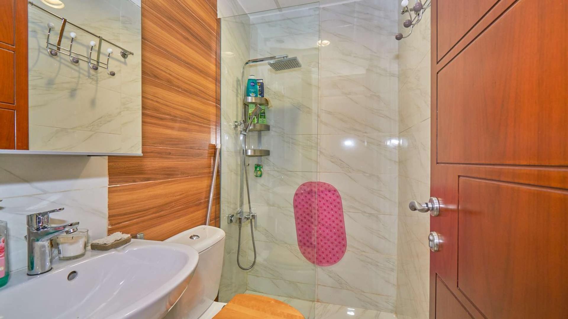 "Charming backyard of fully upgraded Springs villa with lush garden and patio furniture.",Modern bathroom in fully upgraded Springs Villa with marble tiles and glass shower enclosure