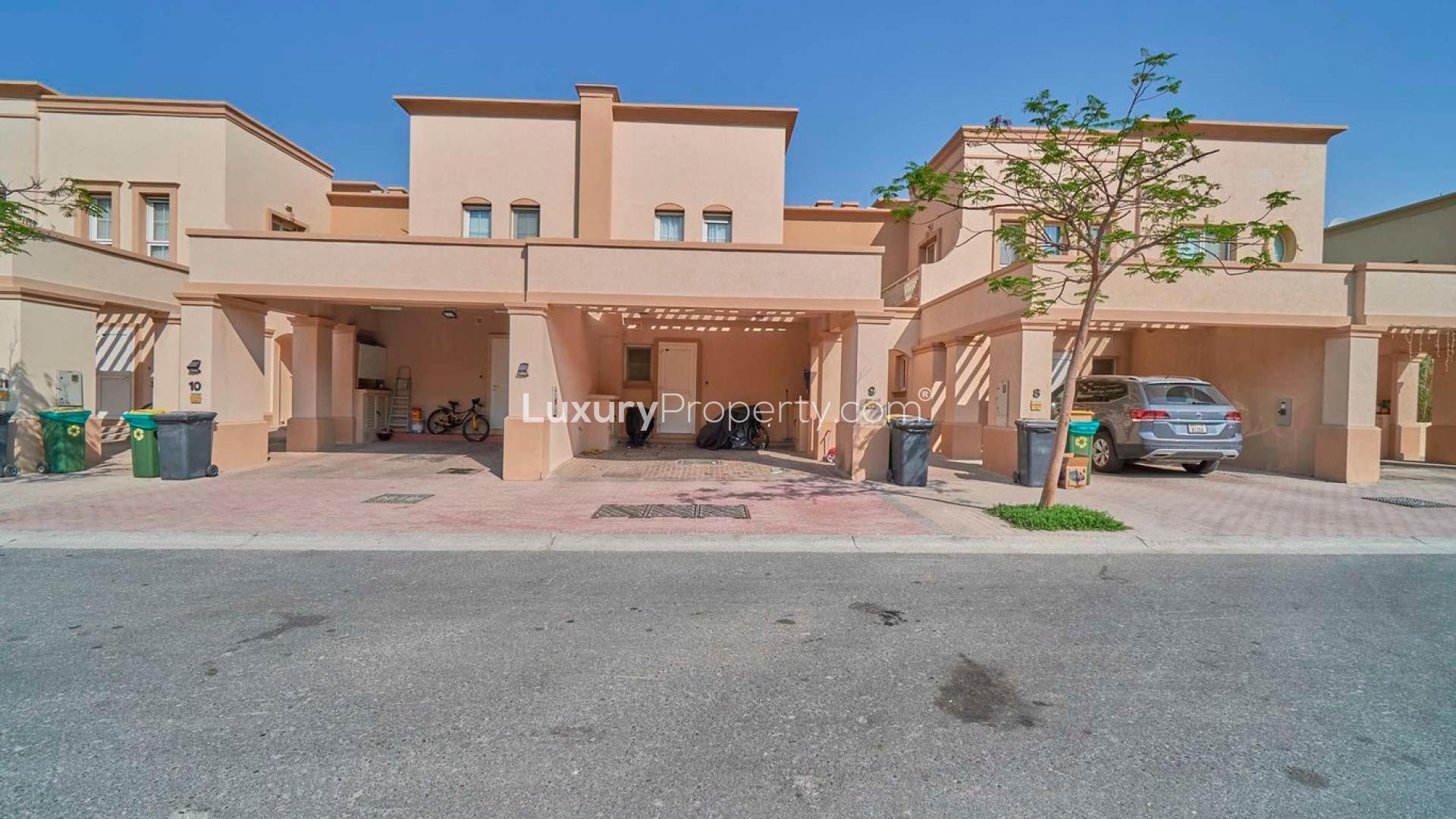 Lush garden space in single row villa, Springs 3, featuring outdoor seating and palm tree