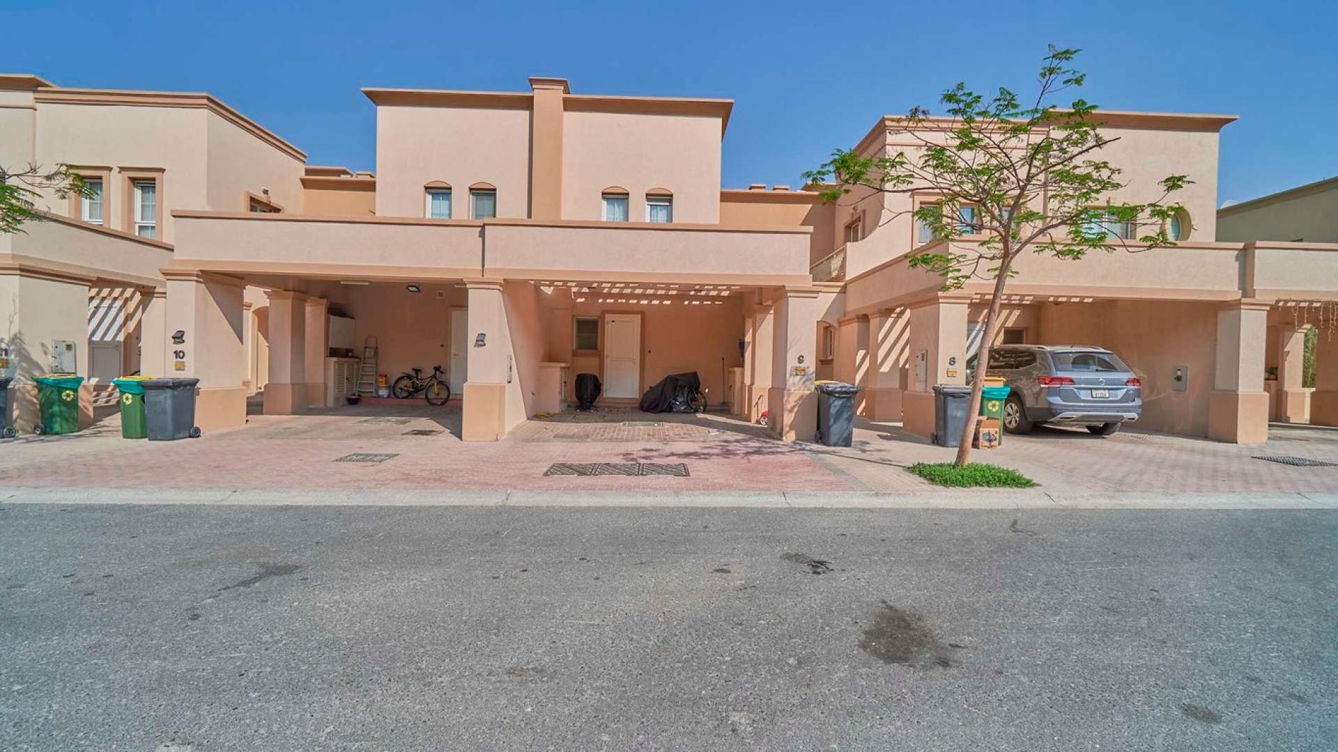 Lush garden space in single row villa, Springs 3, featuring outdoor seating and palm tree