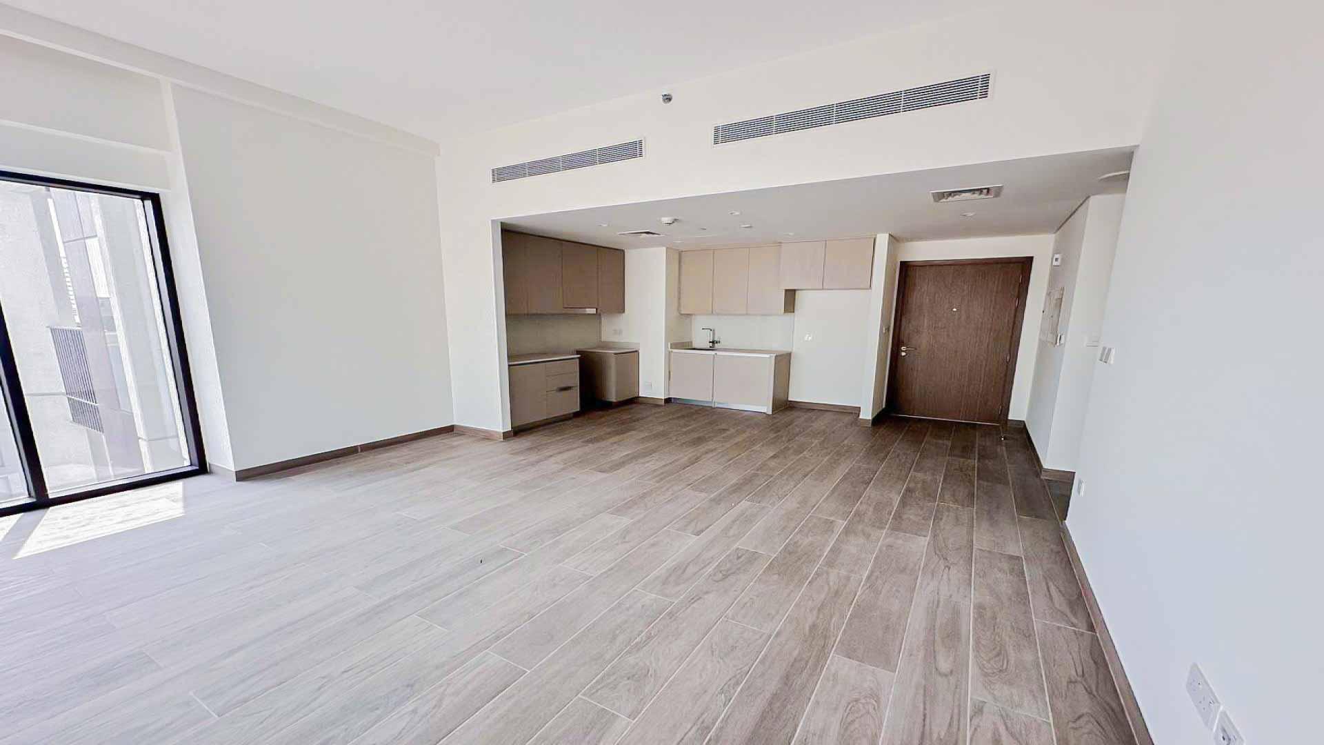 Spacious living area with modern kitchen in Dubai Creek Harbour apartment for rent