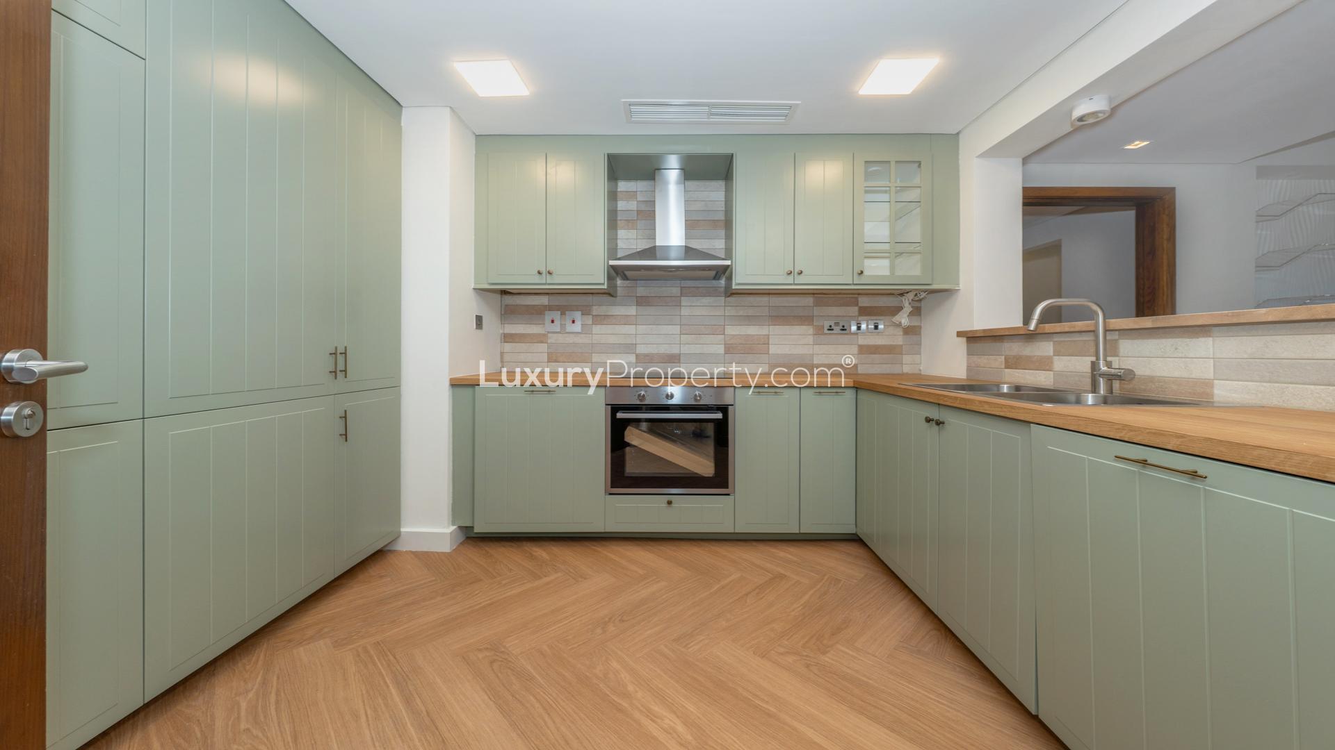 "Modern high-floor apartment interior with wood flooring in Marina Residence, Palm Jumeirah.",Modern kitchen in upgraded high-floor apartment, Palm Jumeirah Marina Residence 4, available for rent