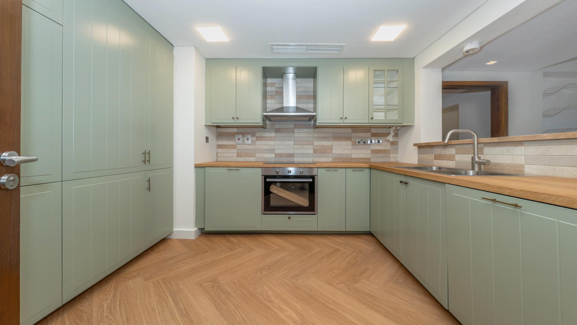 "Modern high-floor apartment interior with wood flooring in Marina Residence, Palm Jumeirah.",Modern kitchen in upgraded high-floor apartment, Palm Jumeirah Marina Residence 4, available for rent