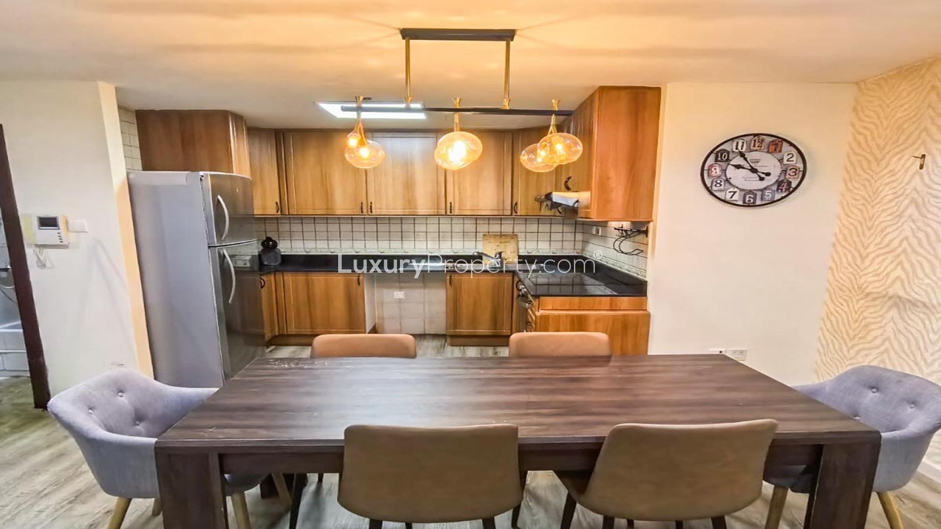 Modern living room in high-floor Dubai Marina apartment, bright decor, large TV, cozy seating