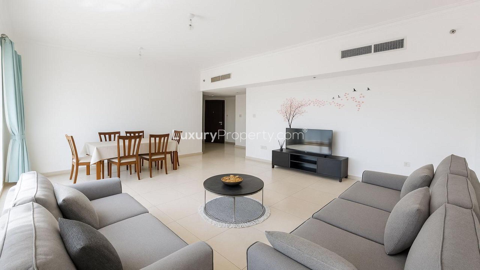 Spacious living room in JLT Lake View apartment with modern furniture and natural light.
