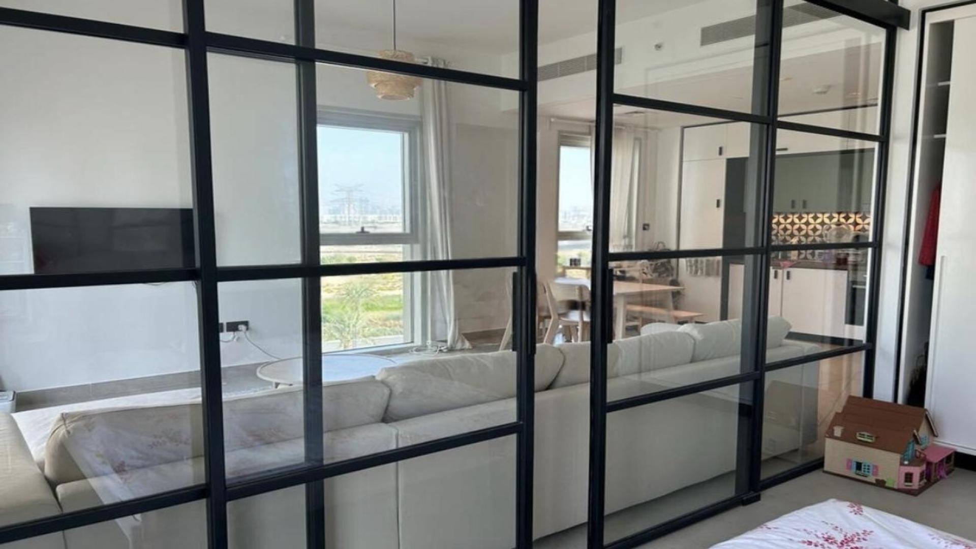 Bright living room in Dubai Hills Estate apartment, featuring modern furniture and city view