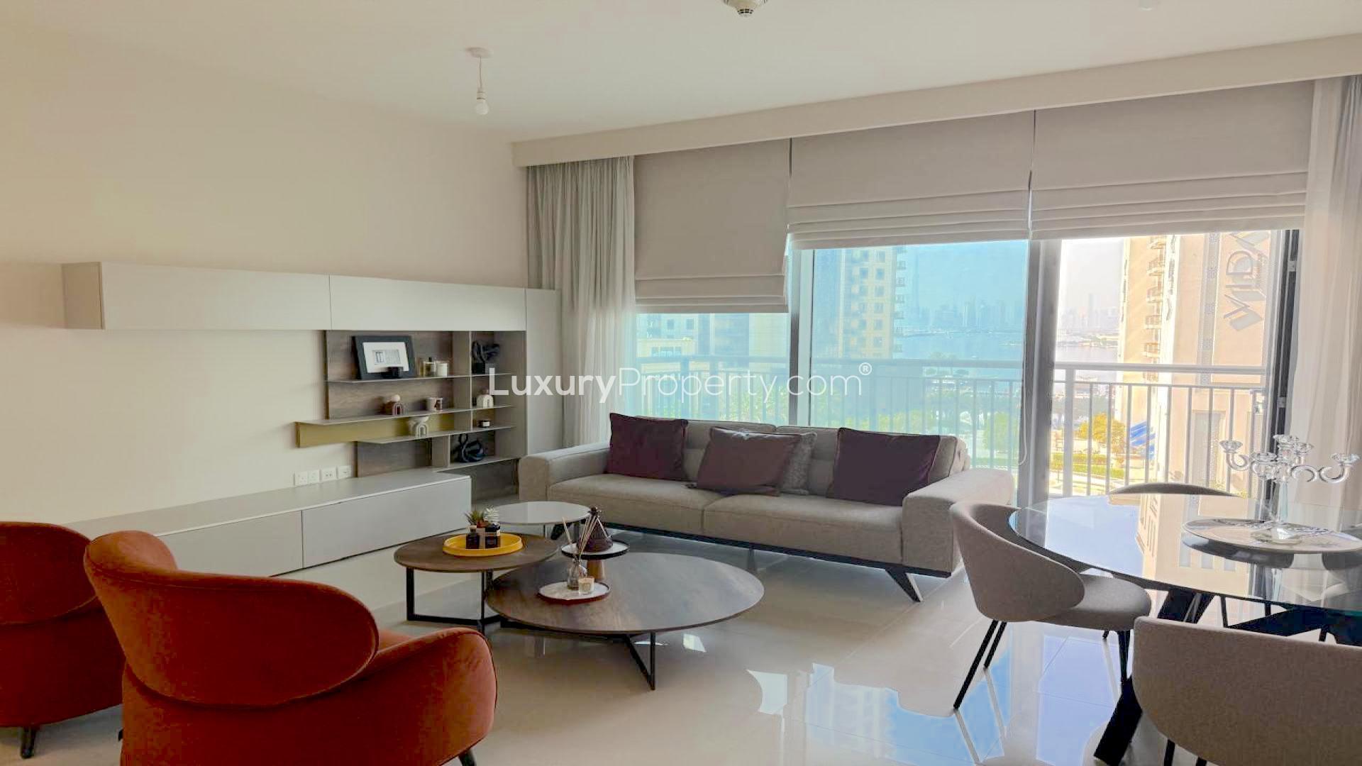 Modern living room in Dubai Creek Harbour apartment with cityscape view through large windows