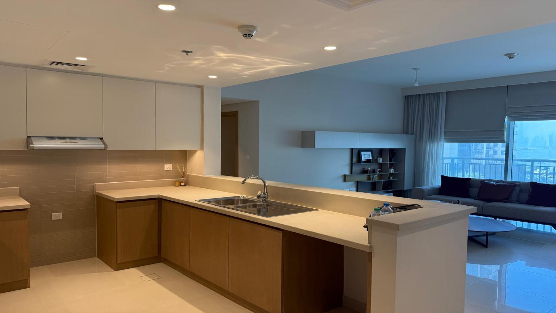 Unfurnished living room in Dubai Creek Harbour apartment with modern decor and open kitchen